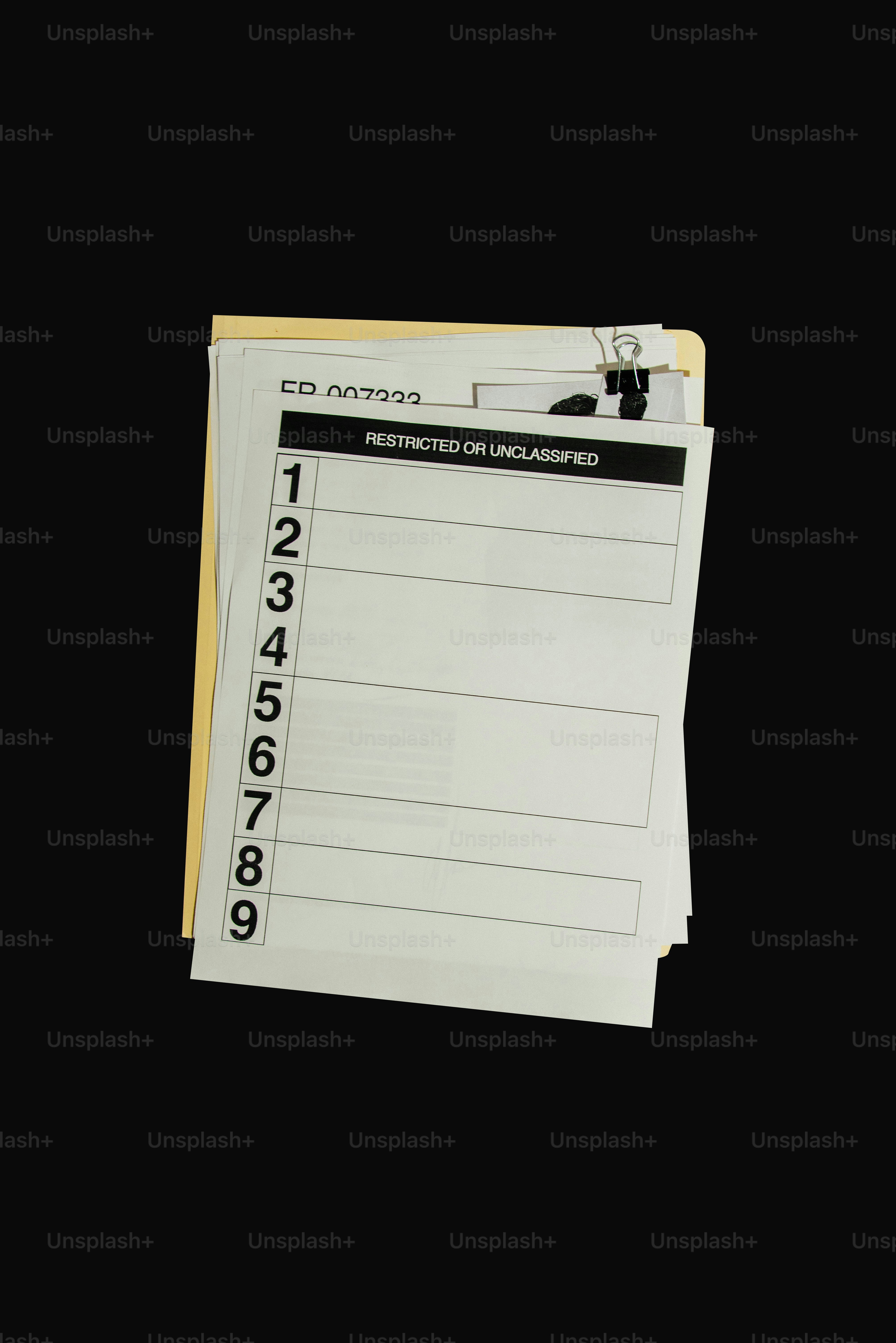 Stack of papers with numbered lines and restricted label.