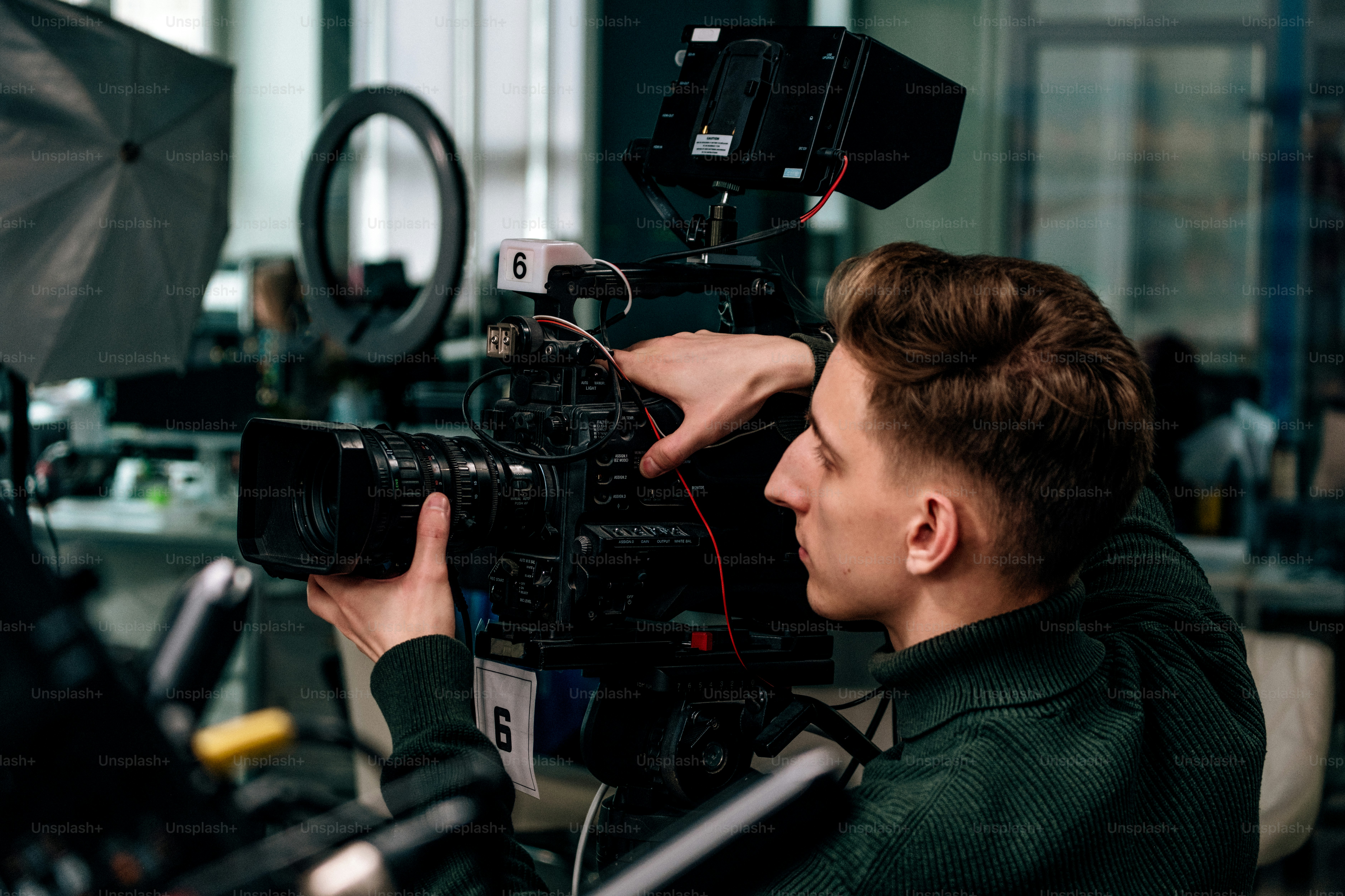 Cameraman operating professional video camera on set.
