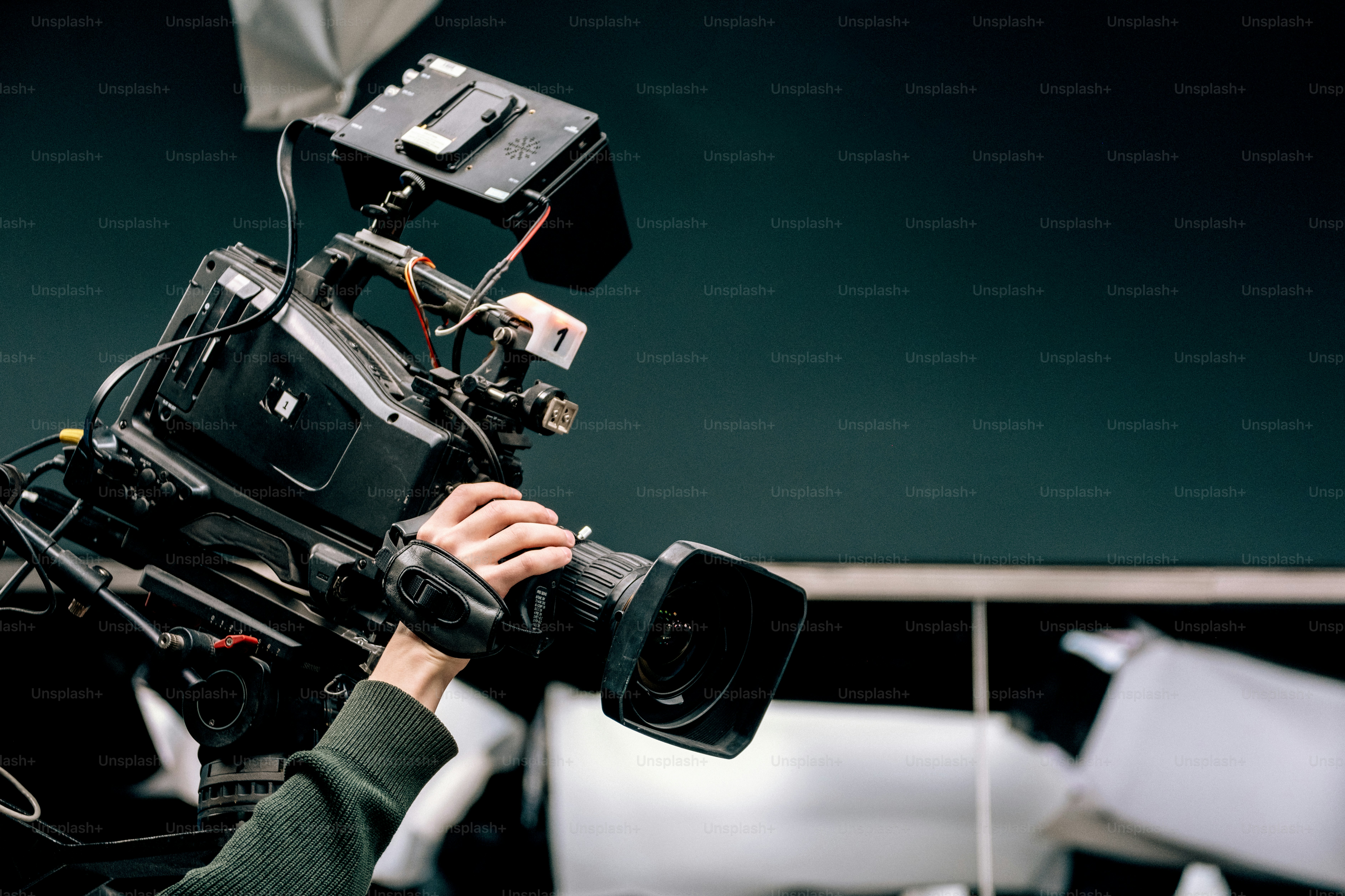 A person holding a professional video camera photo – Camera Image on ...