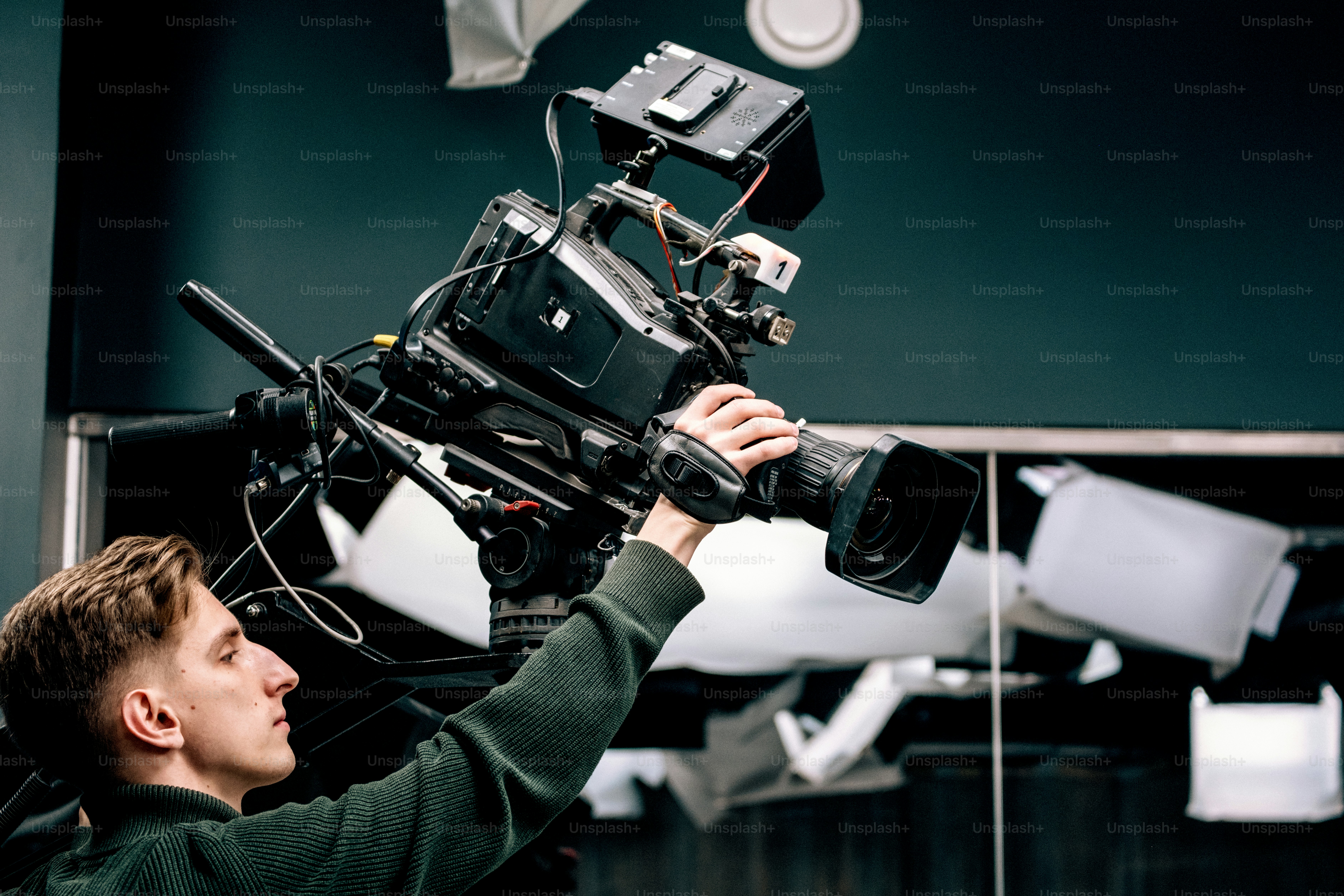 Man operating a professional video camera on set. photo – Camera Image ...