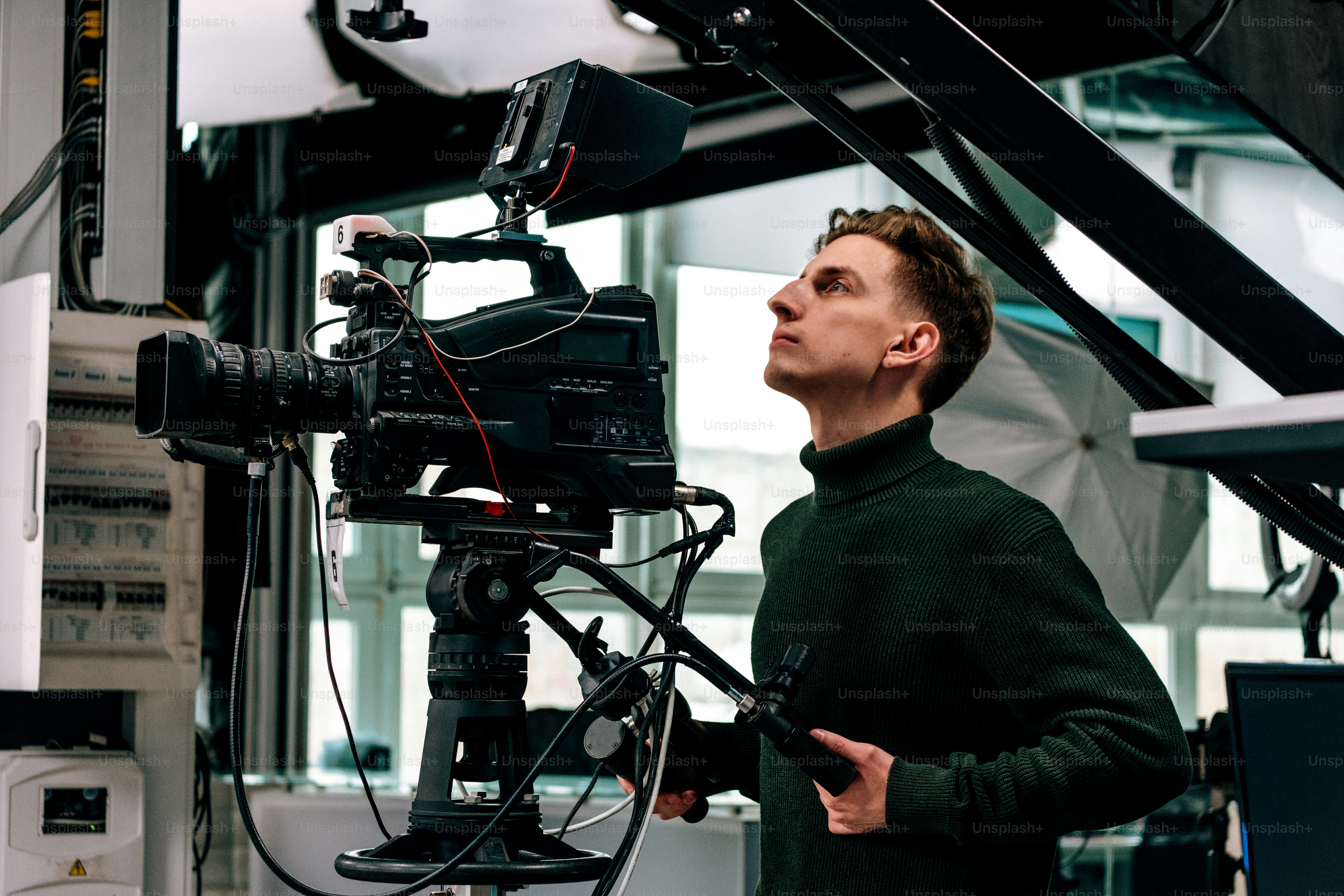 A cameraman operating a professional video camera in studio. photo ...