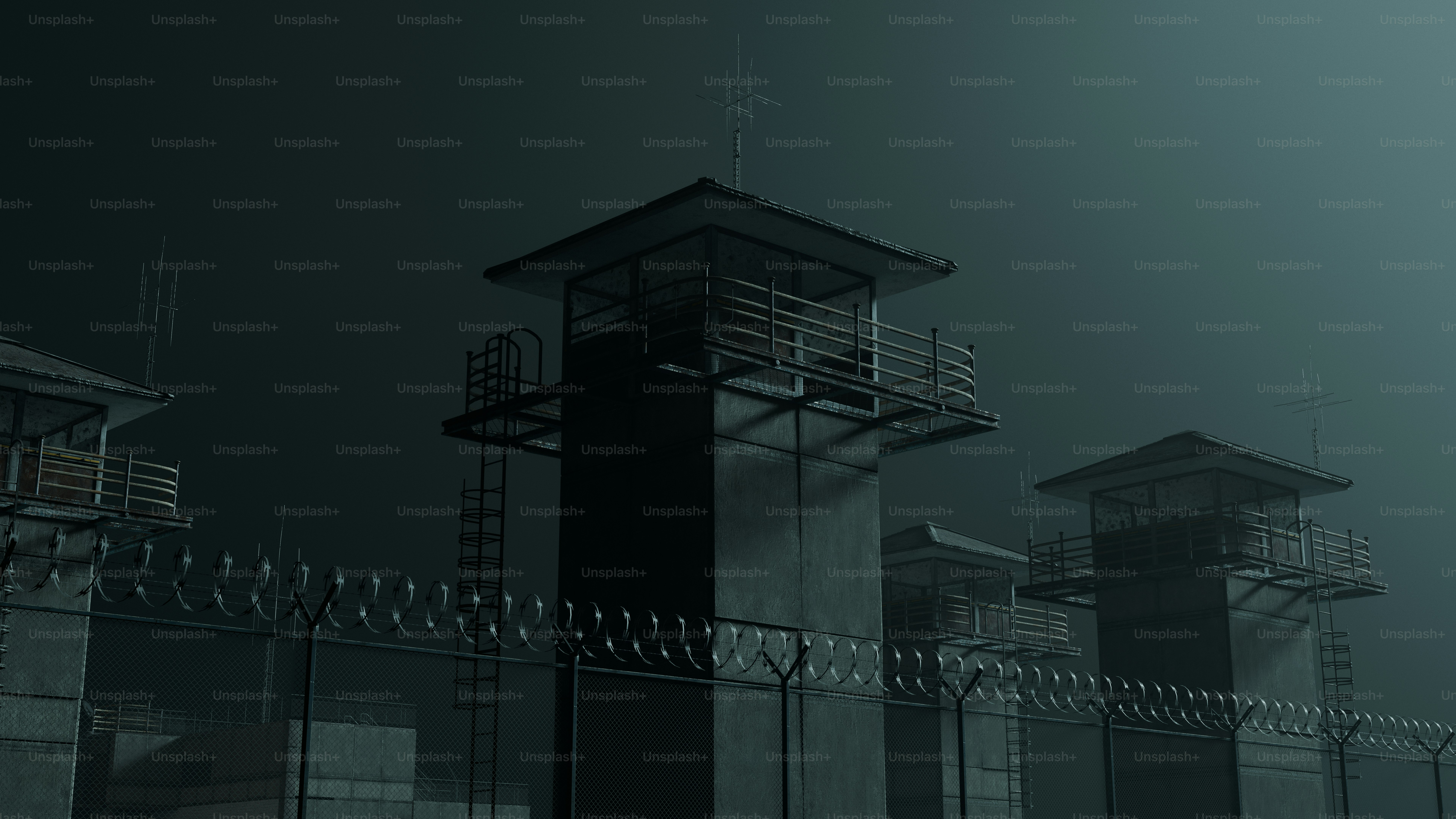 Torri di guardia carcerarie e recinzioni di filo spinato di notte.