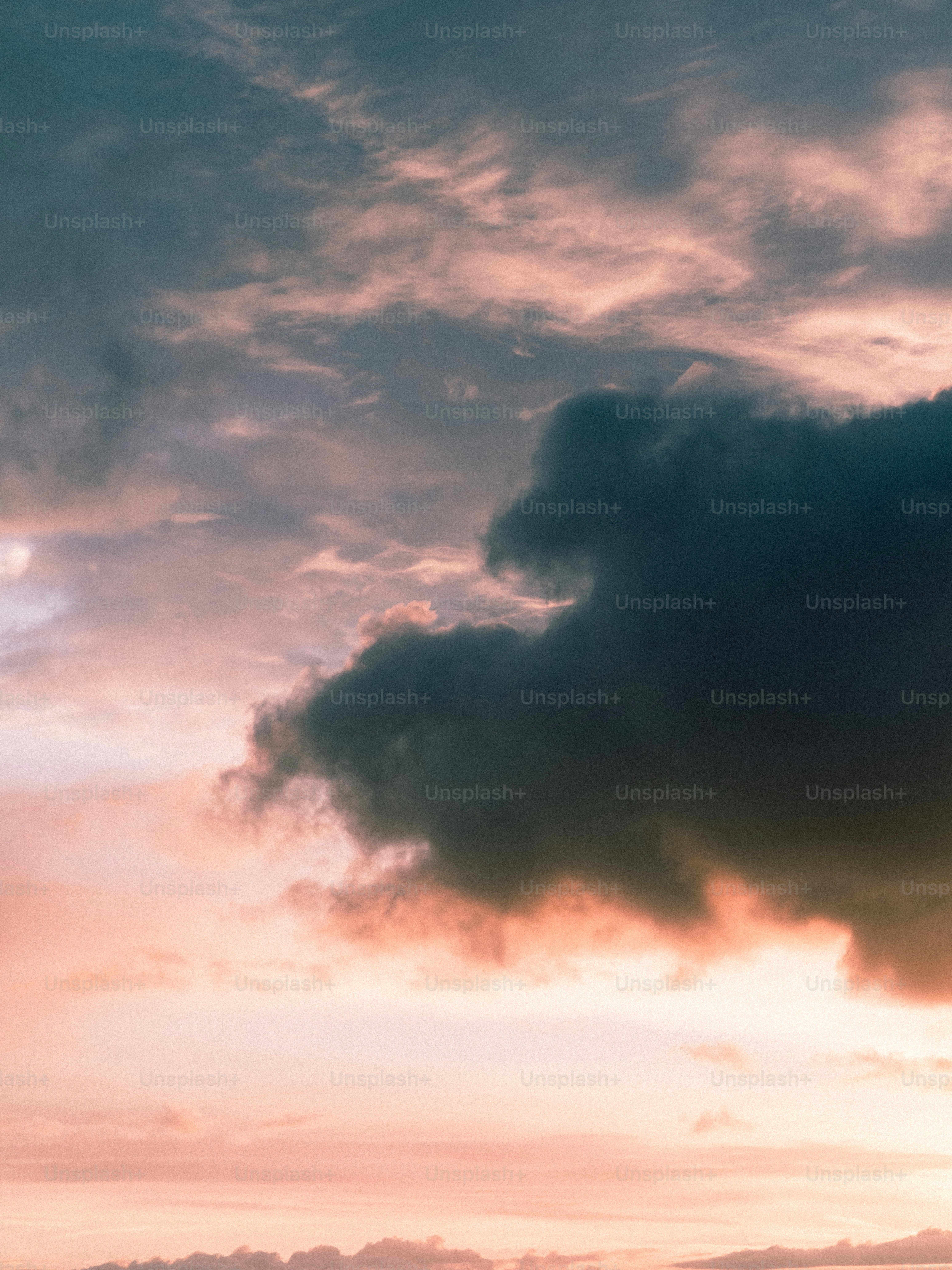 Dramatic dark clouds against a pastel sunset sky