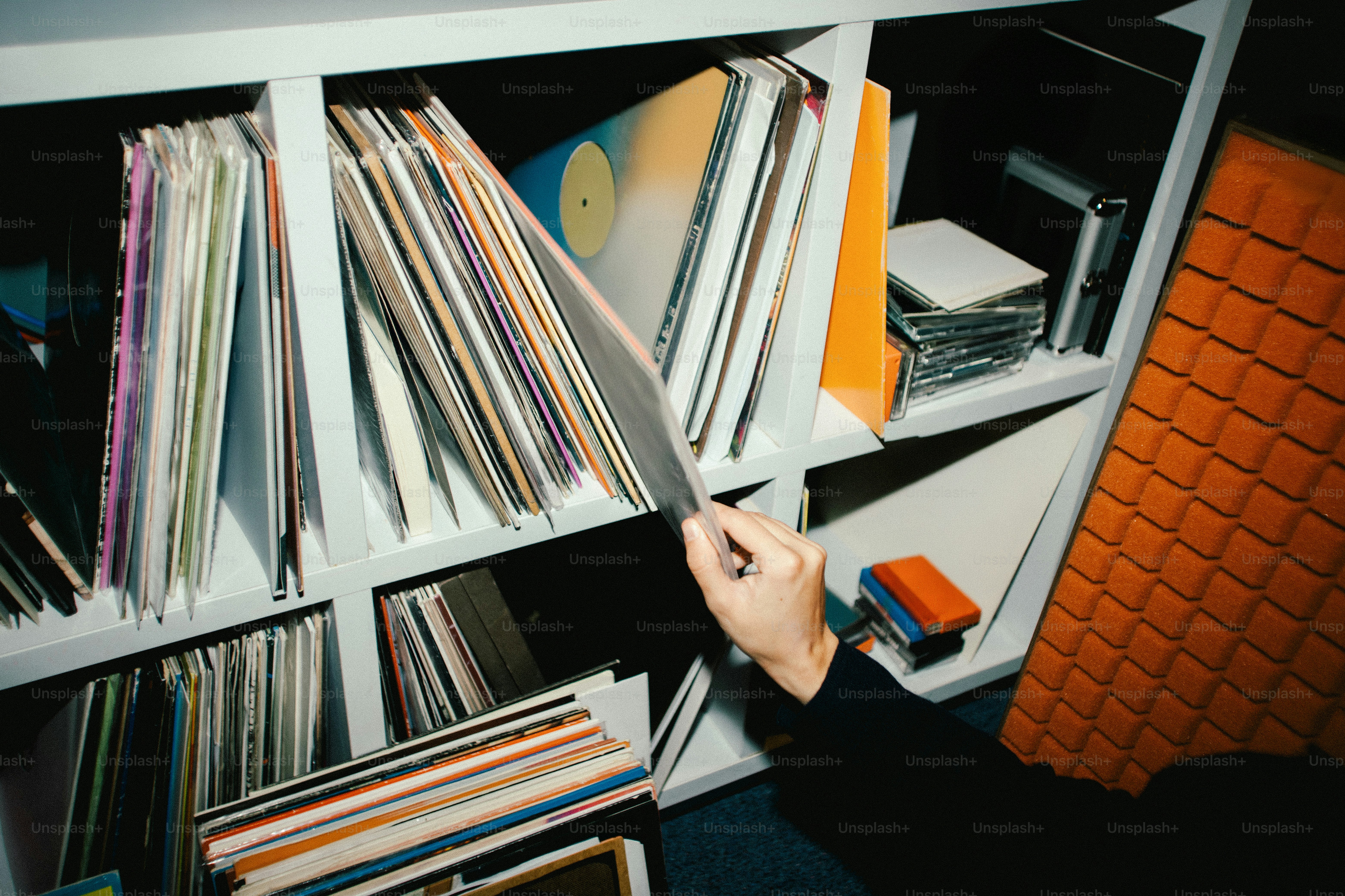 Hand browsing through a shelf of vinyl records.