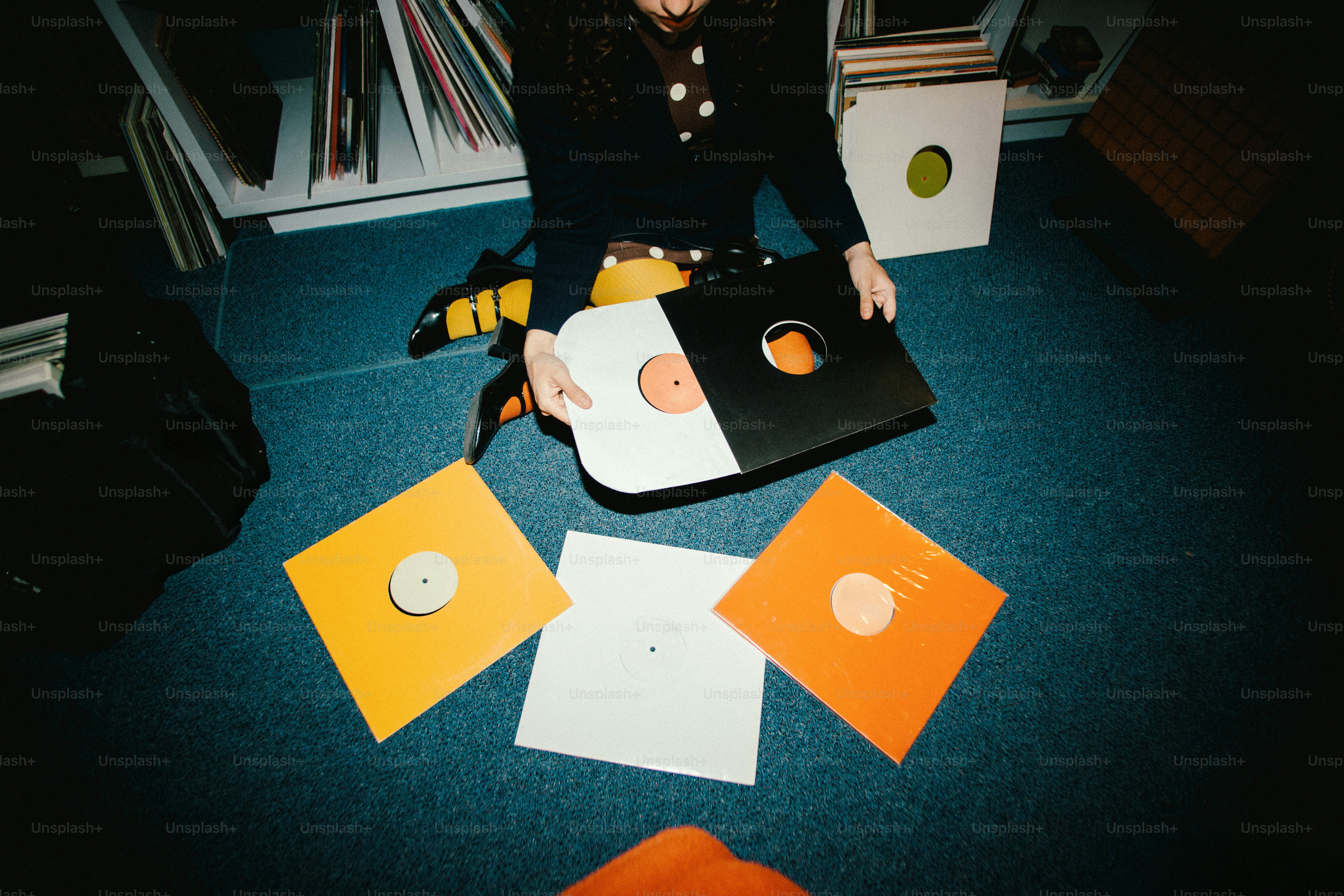 Person holding vinyl records with colorful sleeves