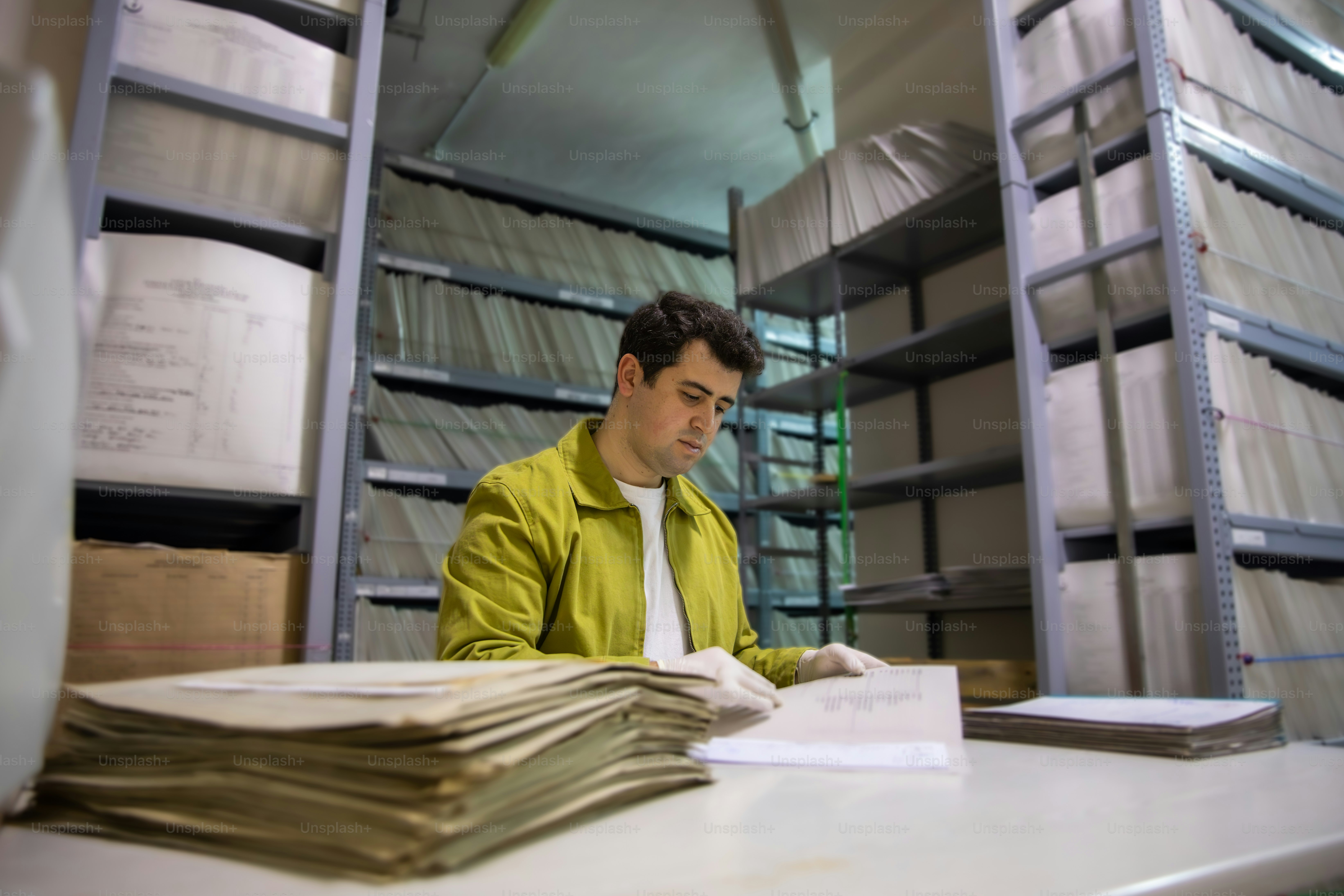 아카이브에서 오래된 문서를 바라보는 남자