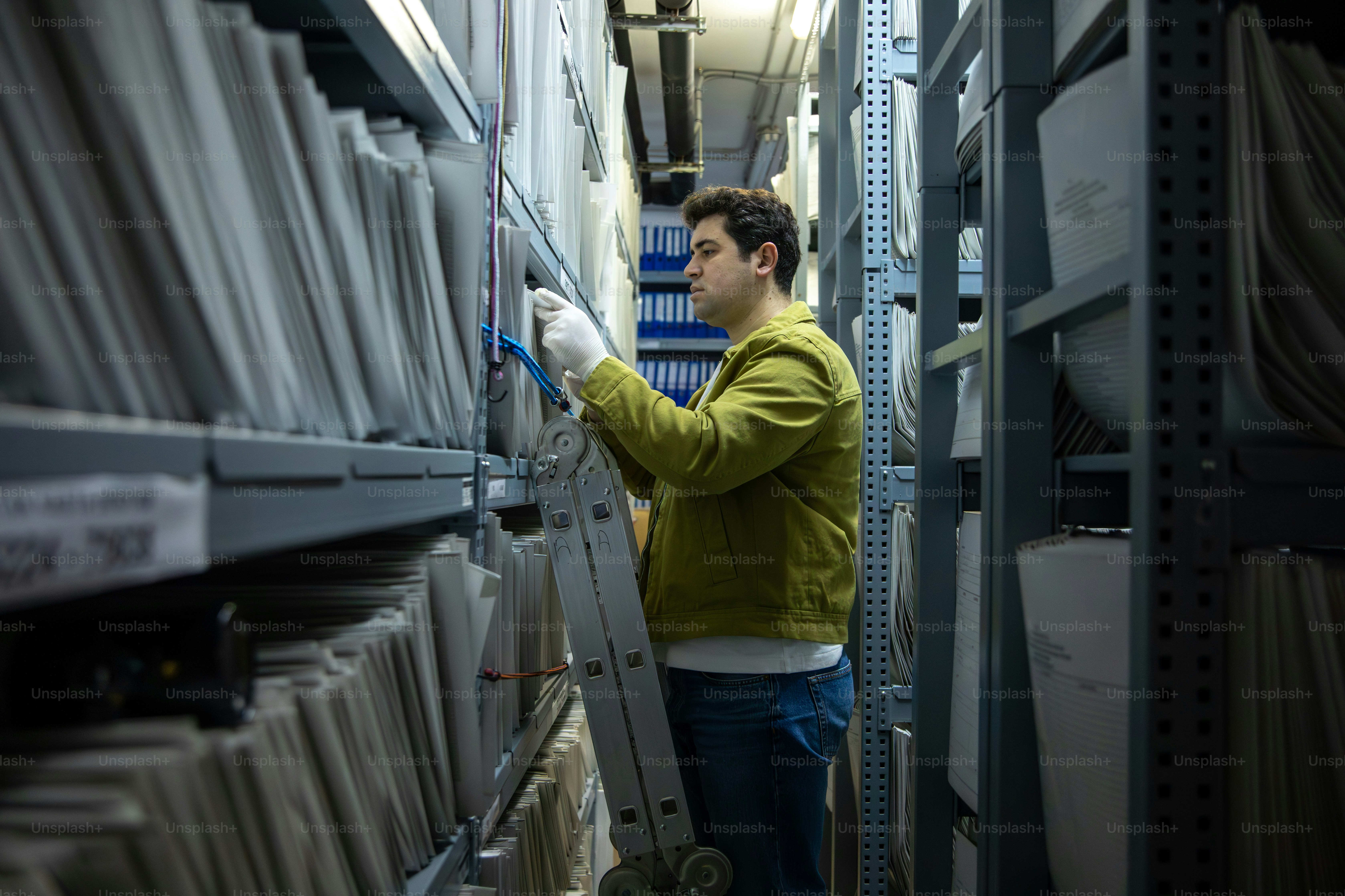 사다리 위 남자가 아카이브 파일을 뒤지고 있다