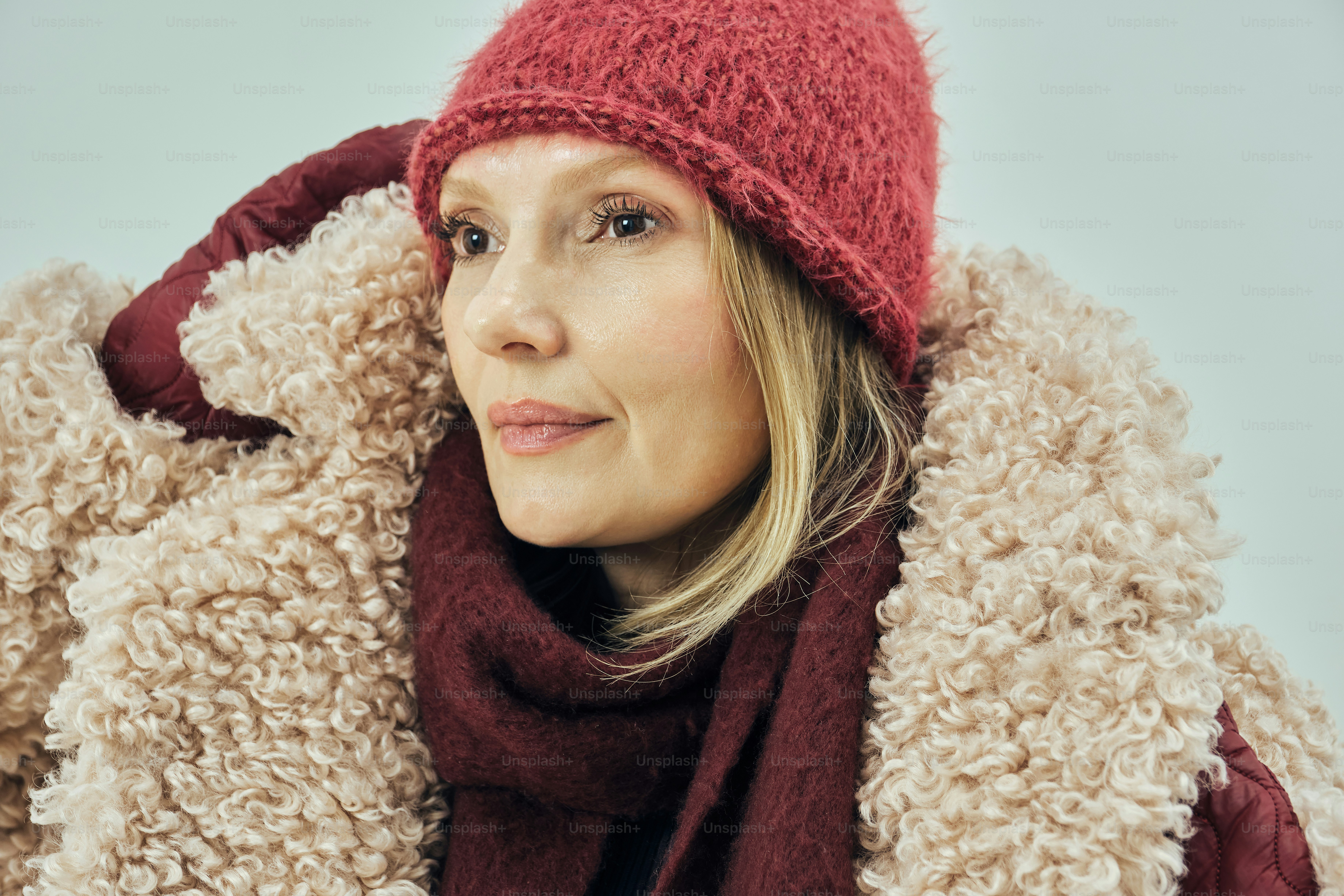 Woman wearing a pink knit hat and fuzzy coat