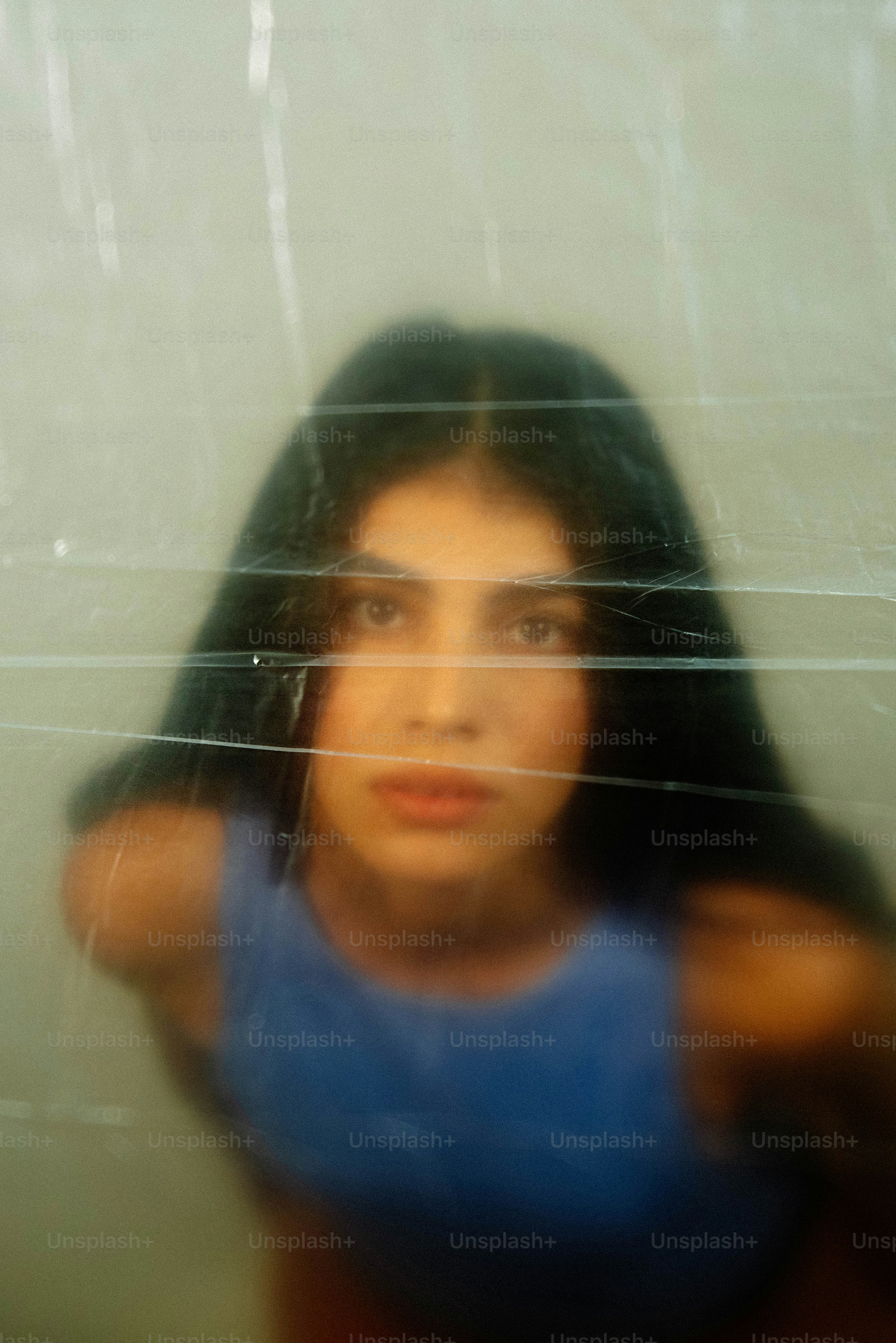 Jovem mulher atrás de filme plástico texturizado