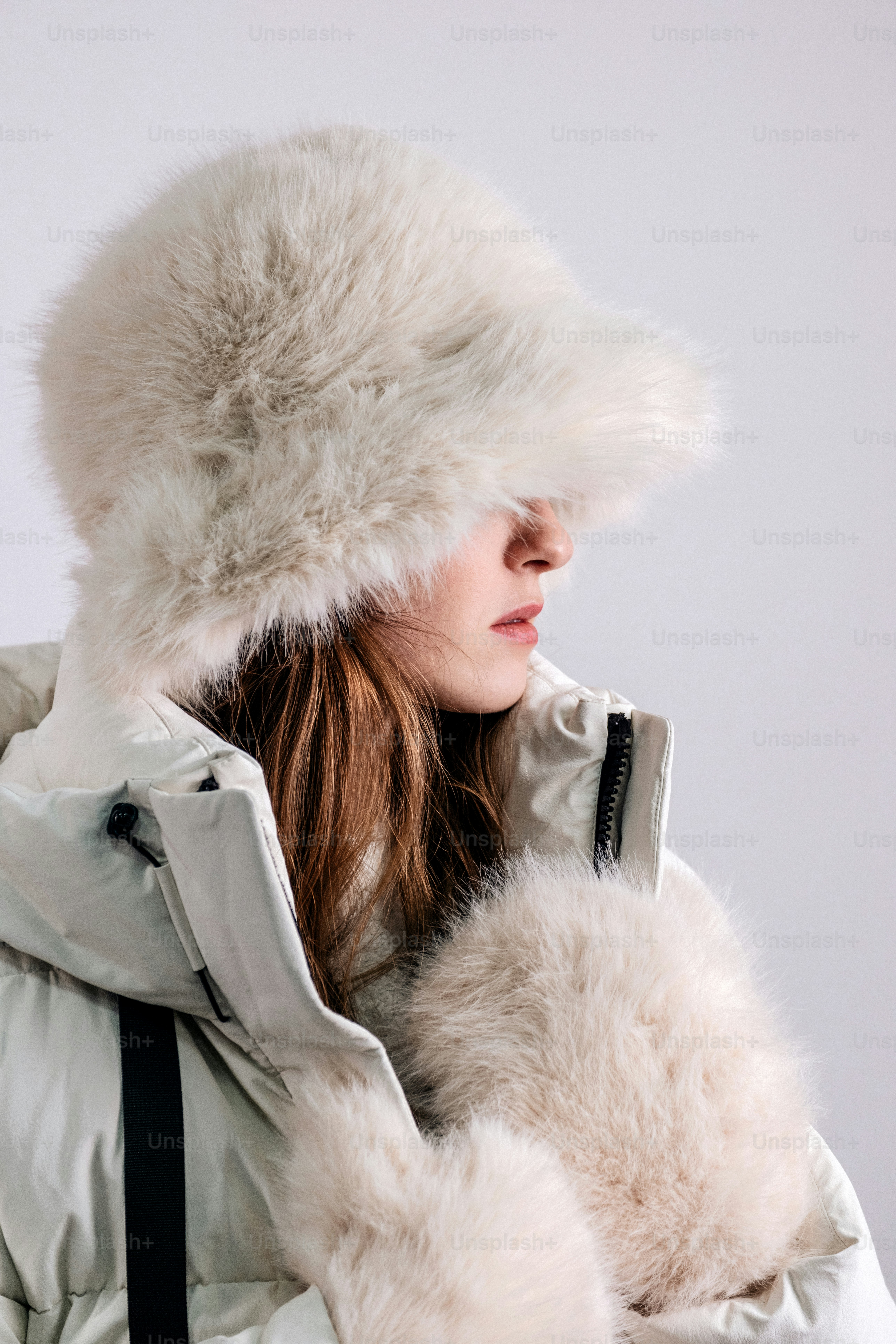 Woman wearing a fluffy white winter hat and coat