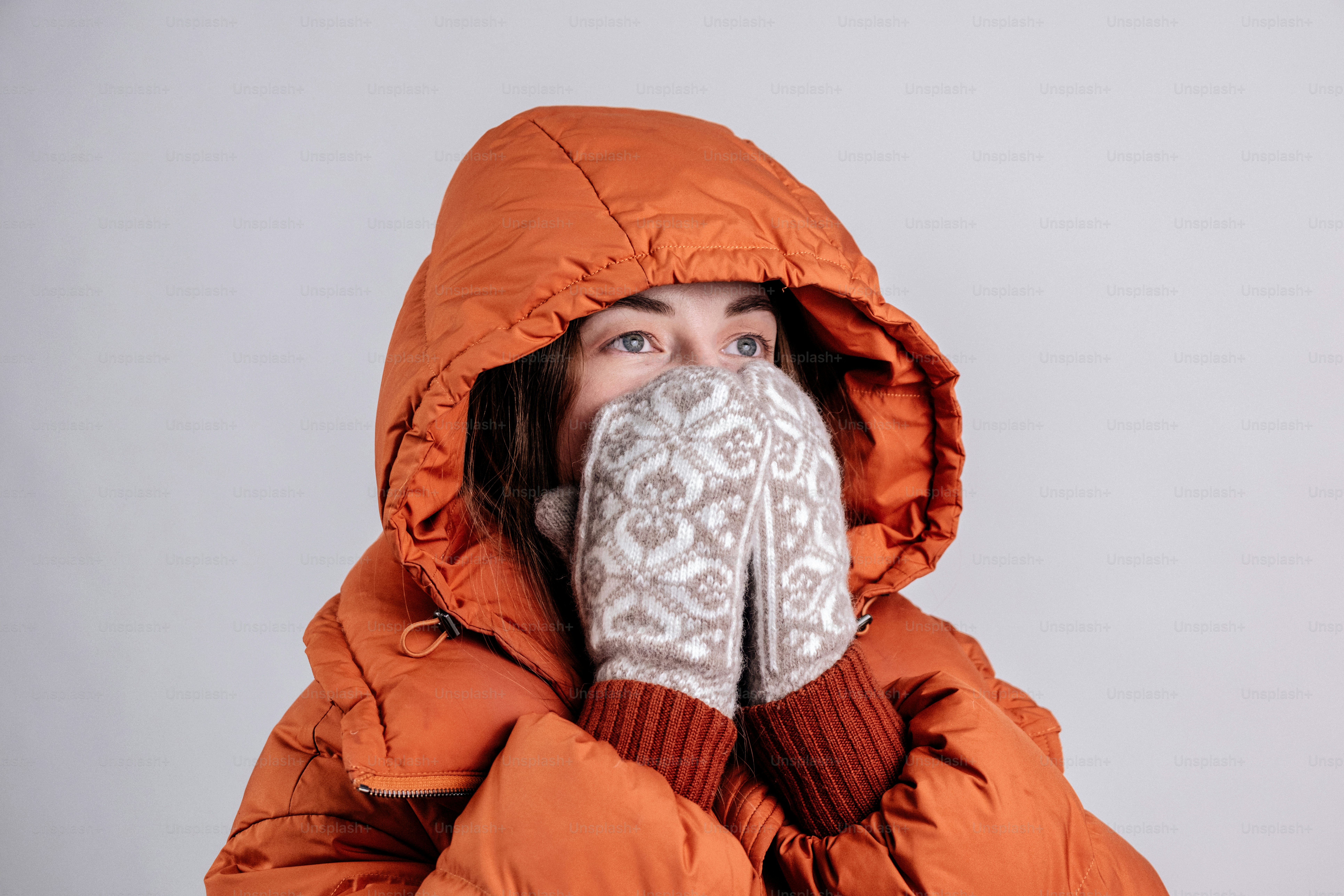 Mujer con chaqueta acolchada naranja y manoplas