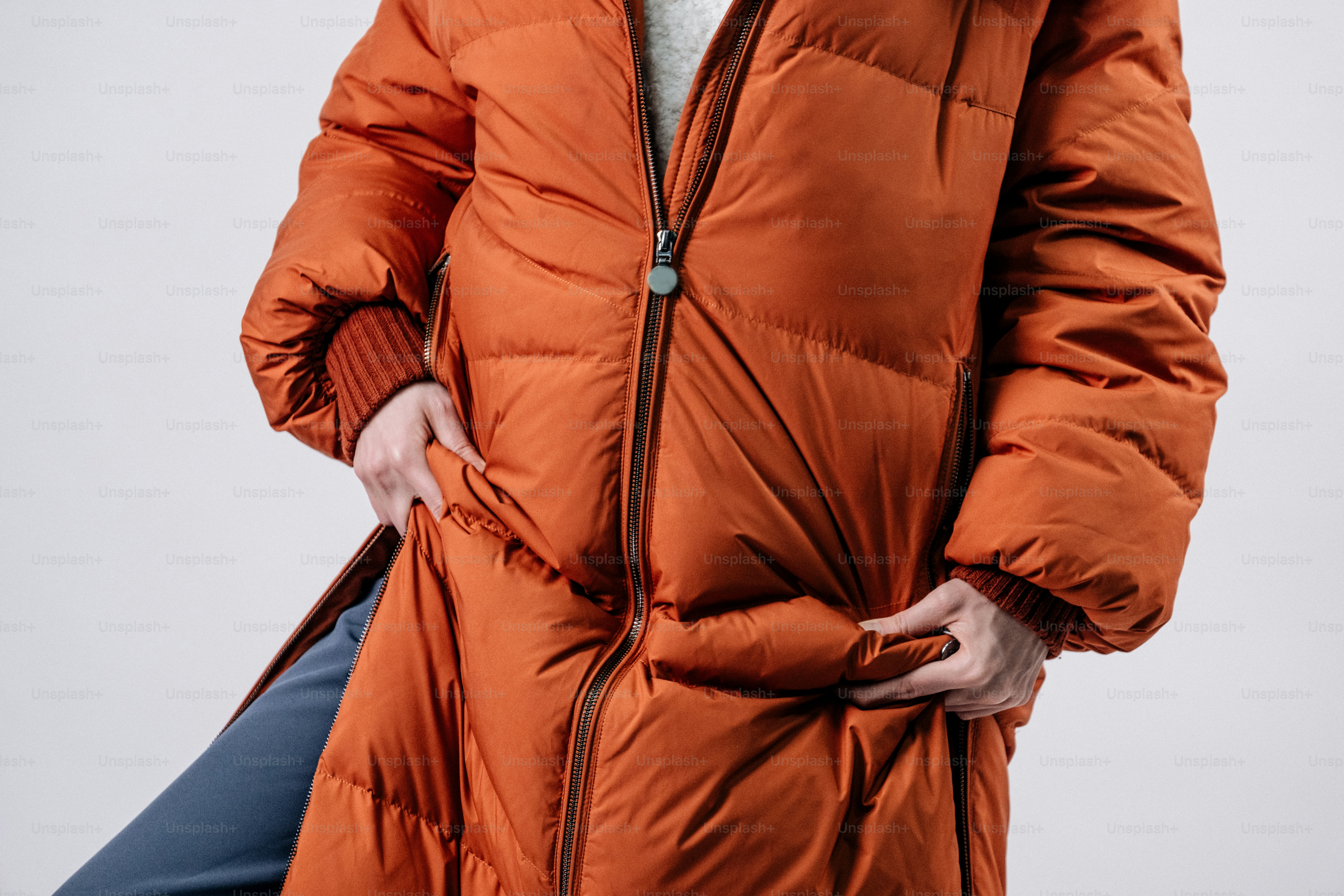 Person wearing a long orange puffer coat