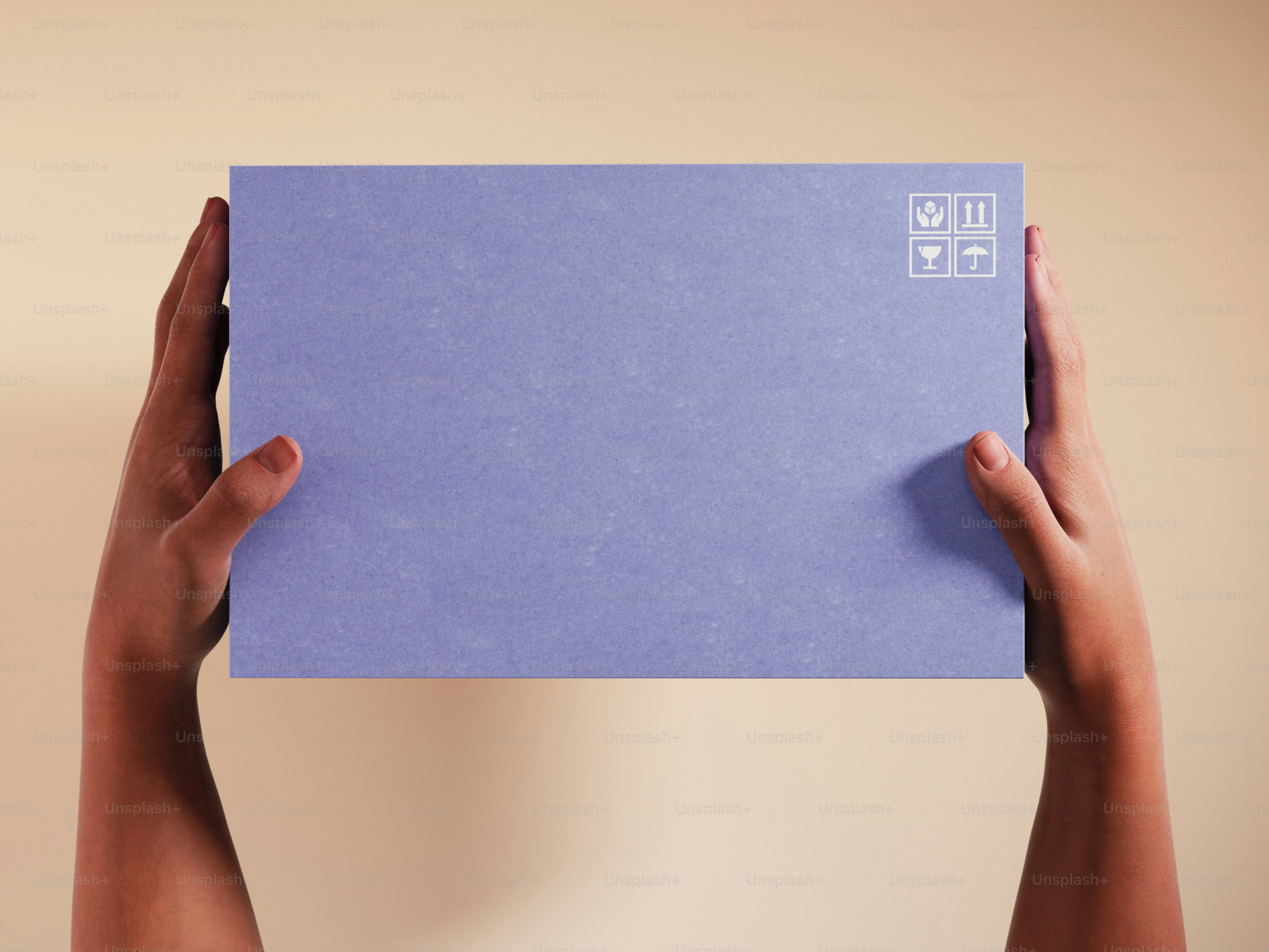 Hands holding a light purple box with symbols.