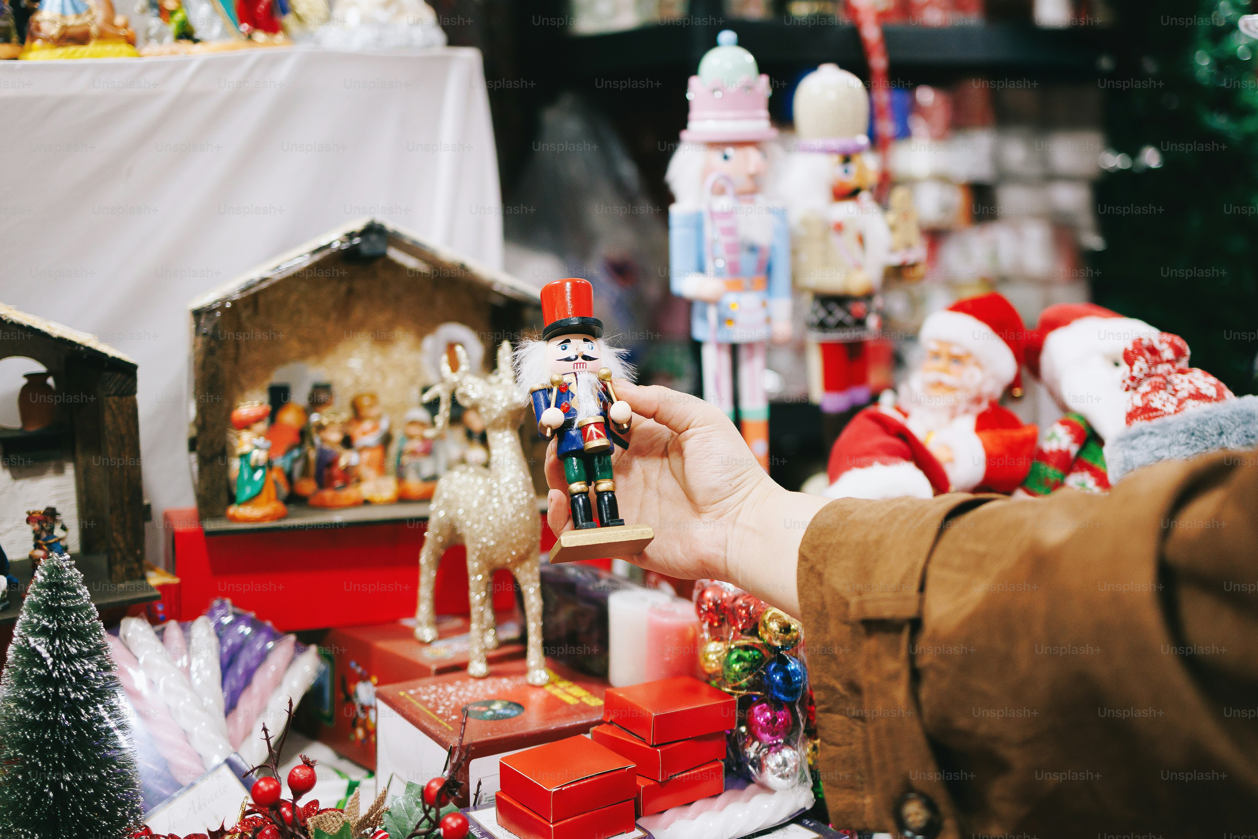 Hand holding a nutcracker over christmas decorations