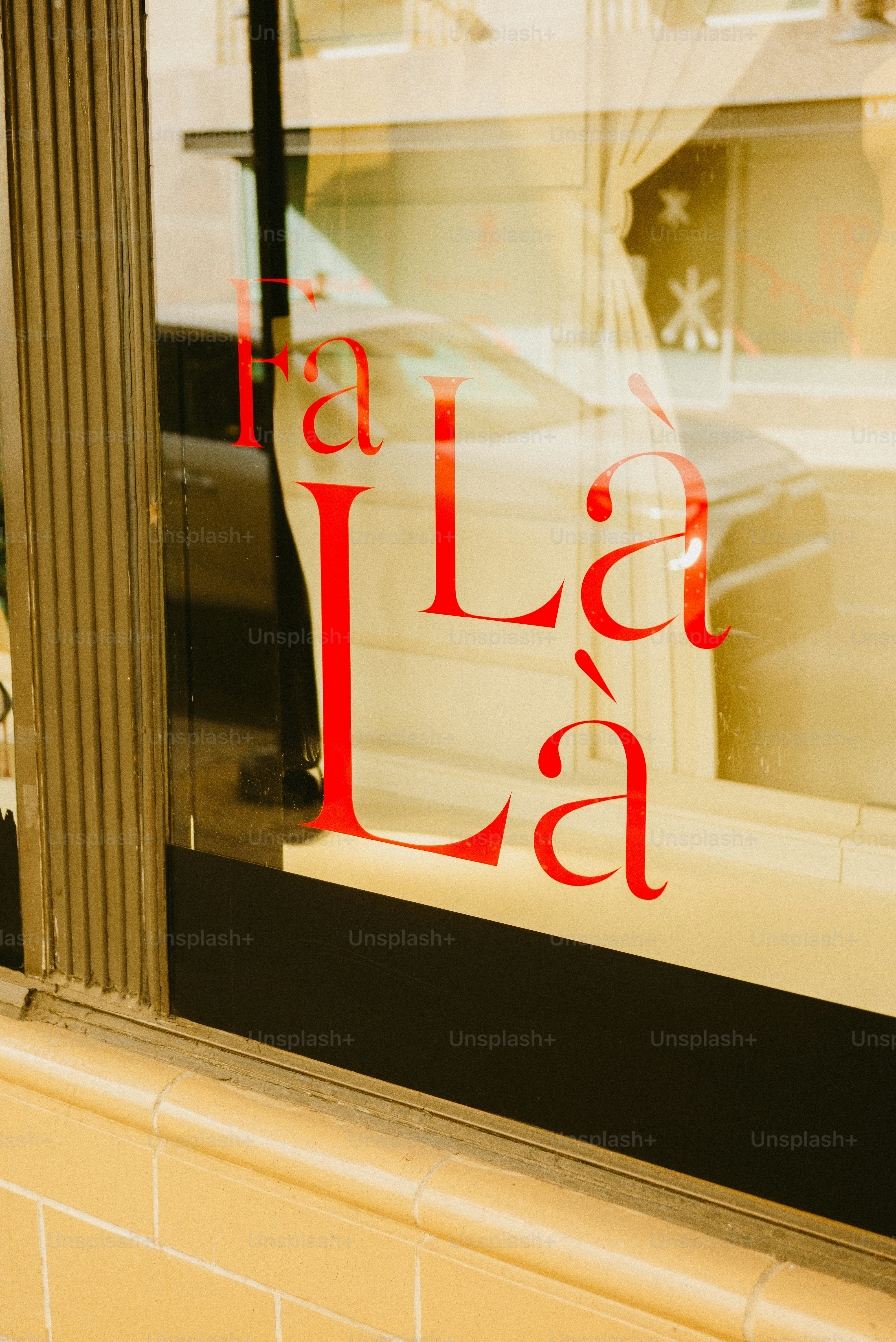 Red 'la la la' text on shop window