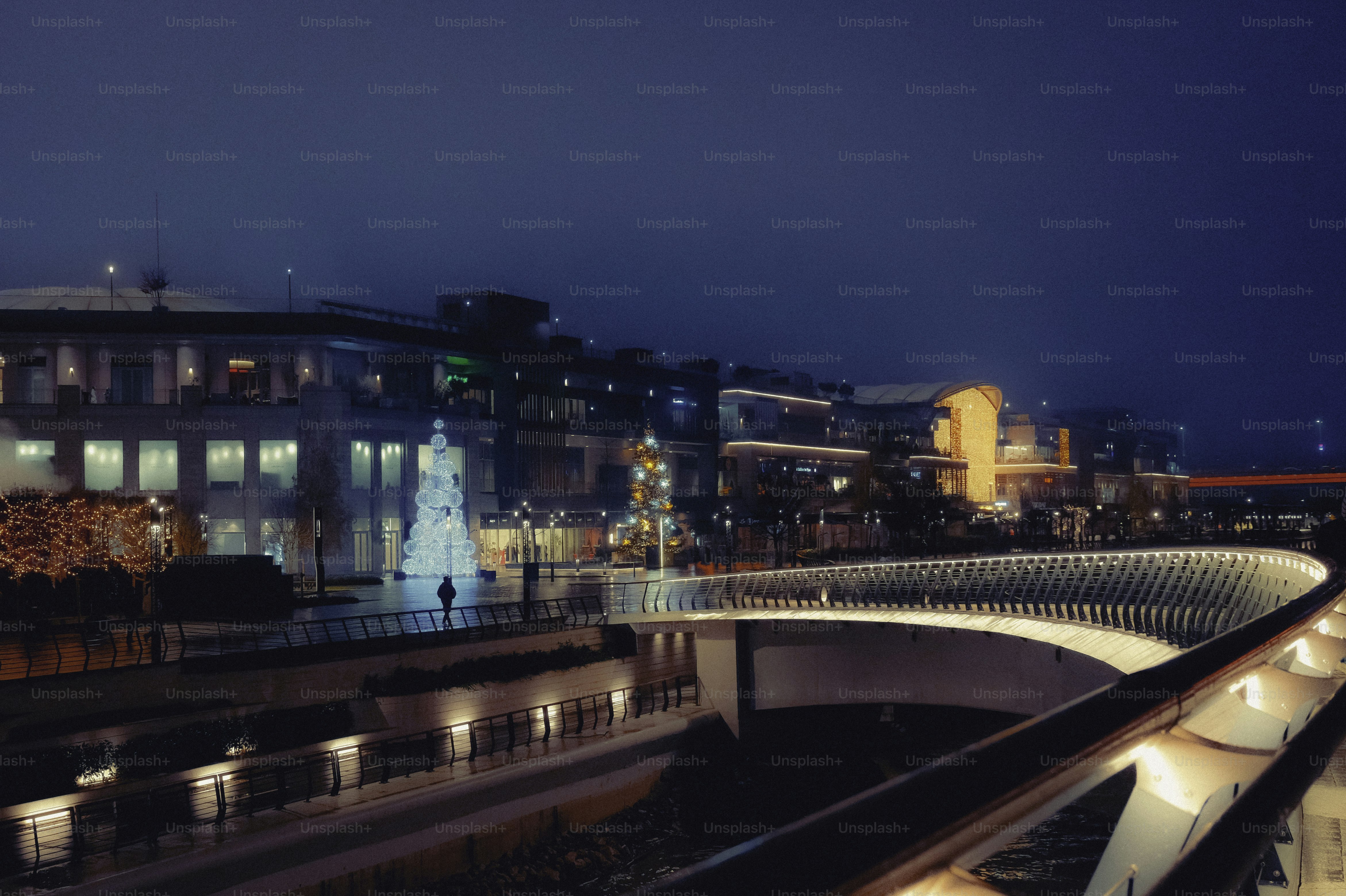 Moderne Gebäude werden nachts mit einer Brücke beleuchtet.