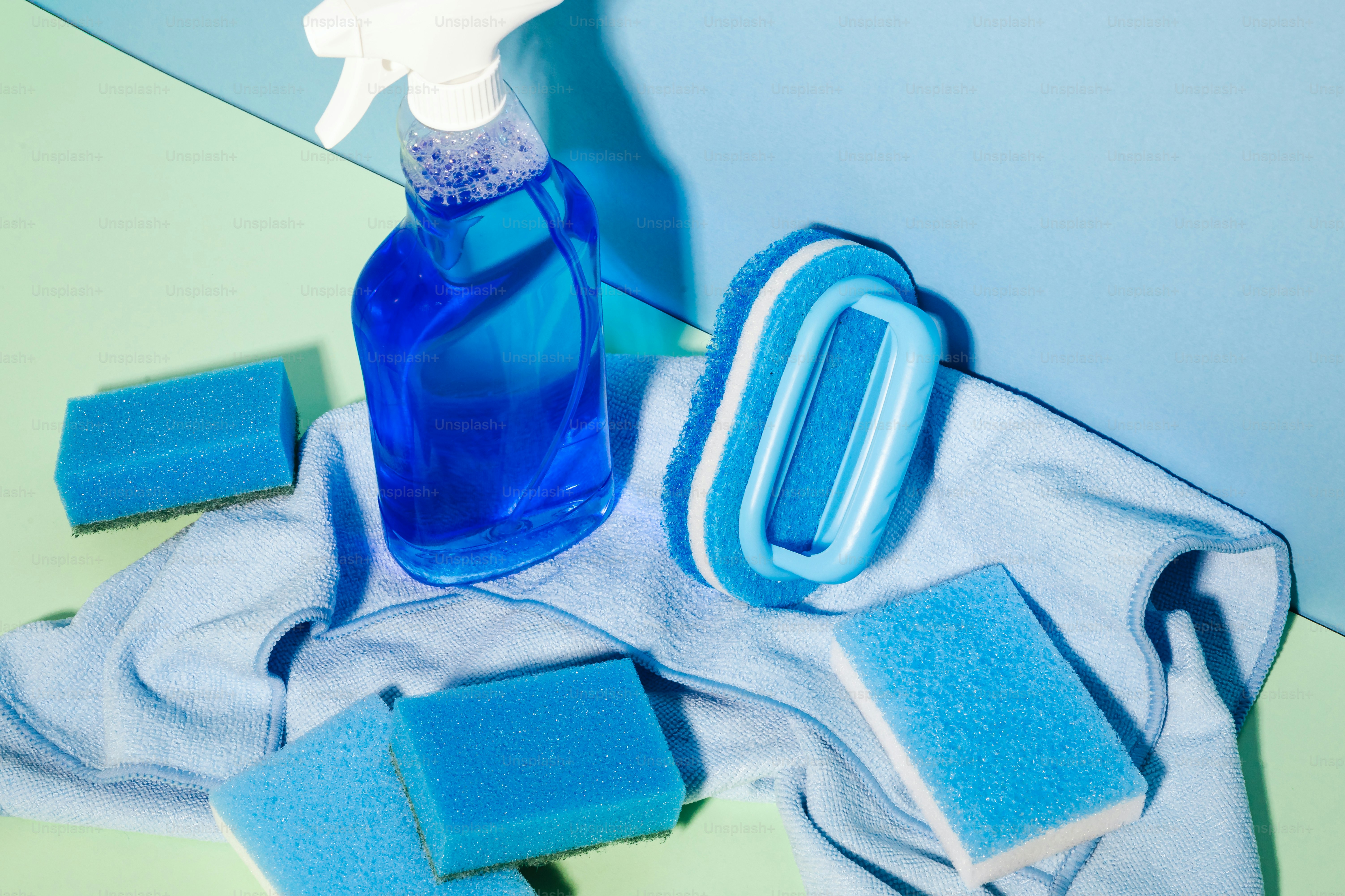 Cleaning supplies including sponges, spray bottle, and cloth.