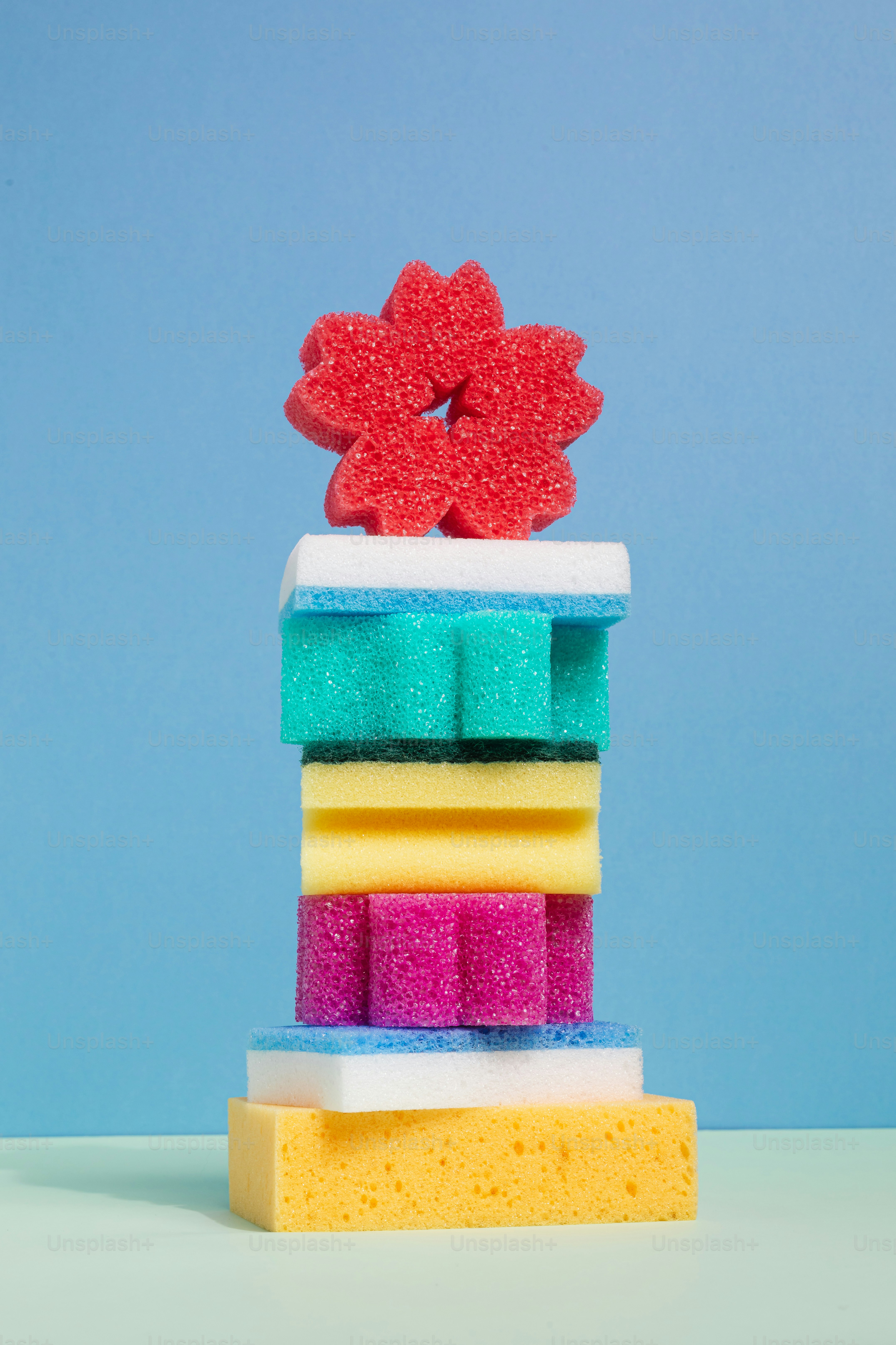 Stack of colorful sponges topped with red flower