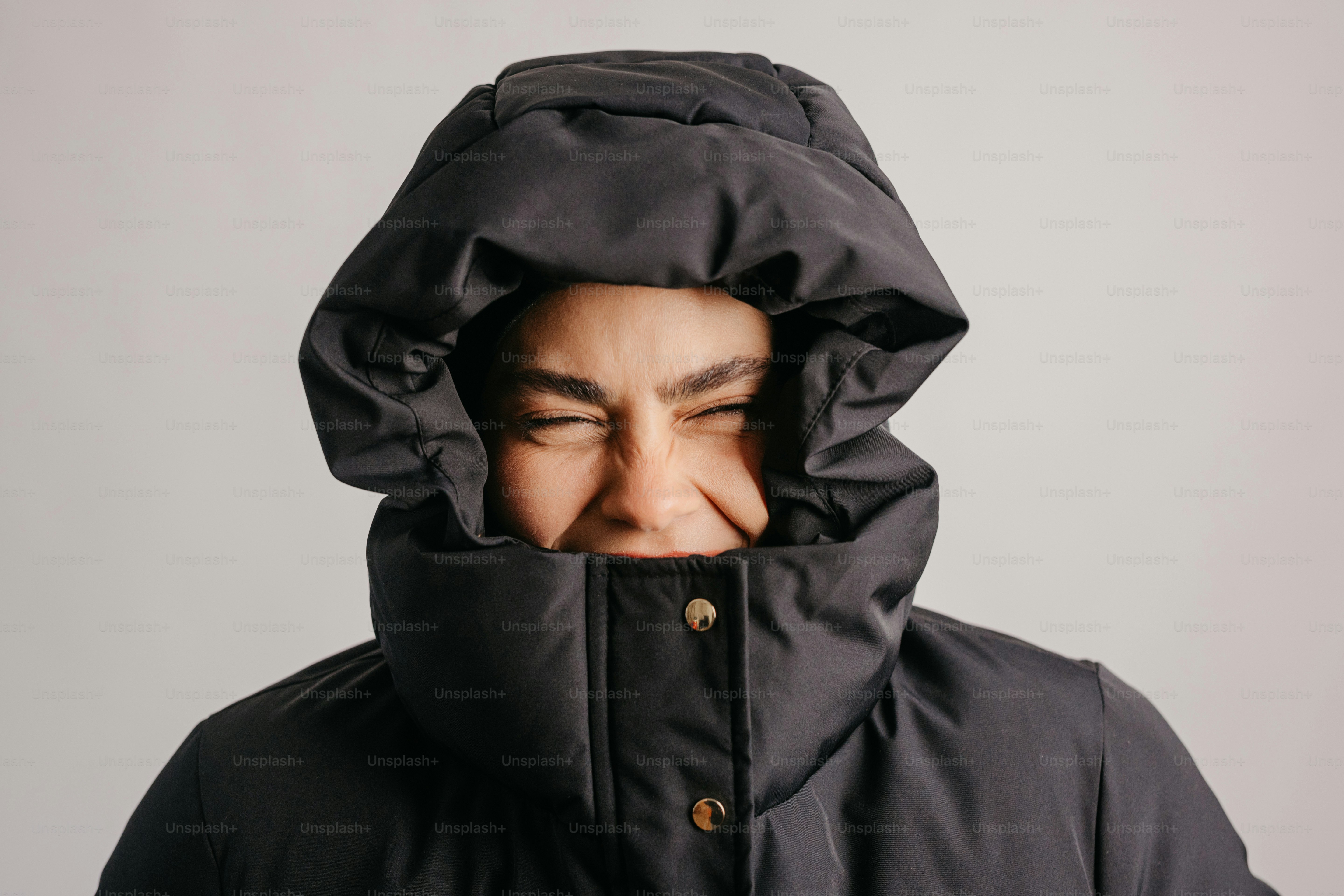 A person bundled up in a dark hooded coat