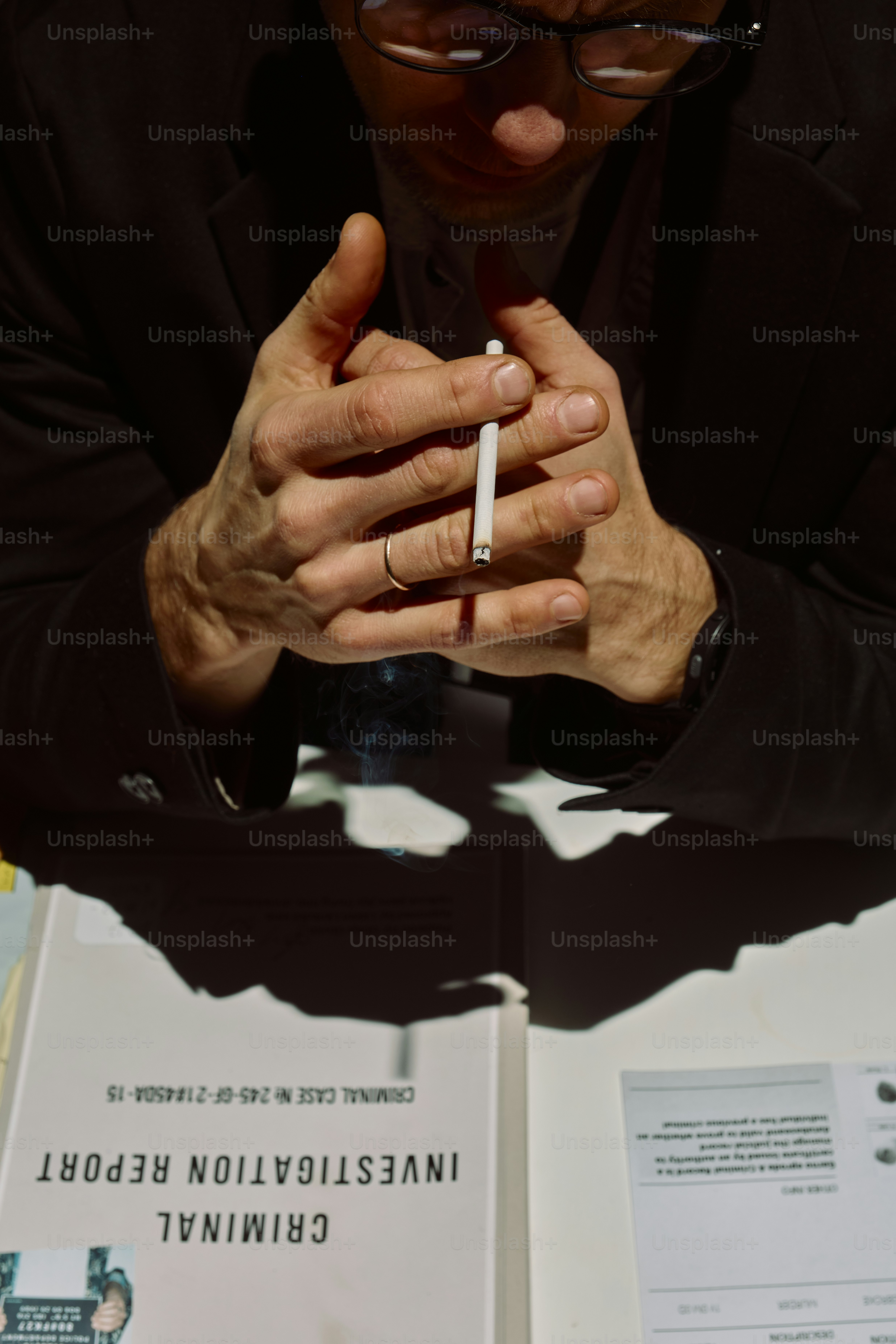 Man holding cigarette over investigation report