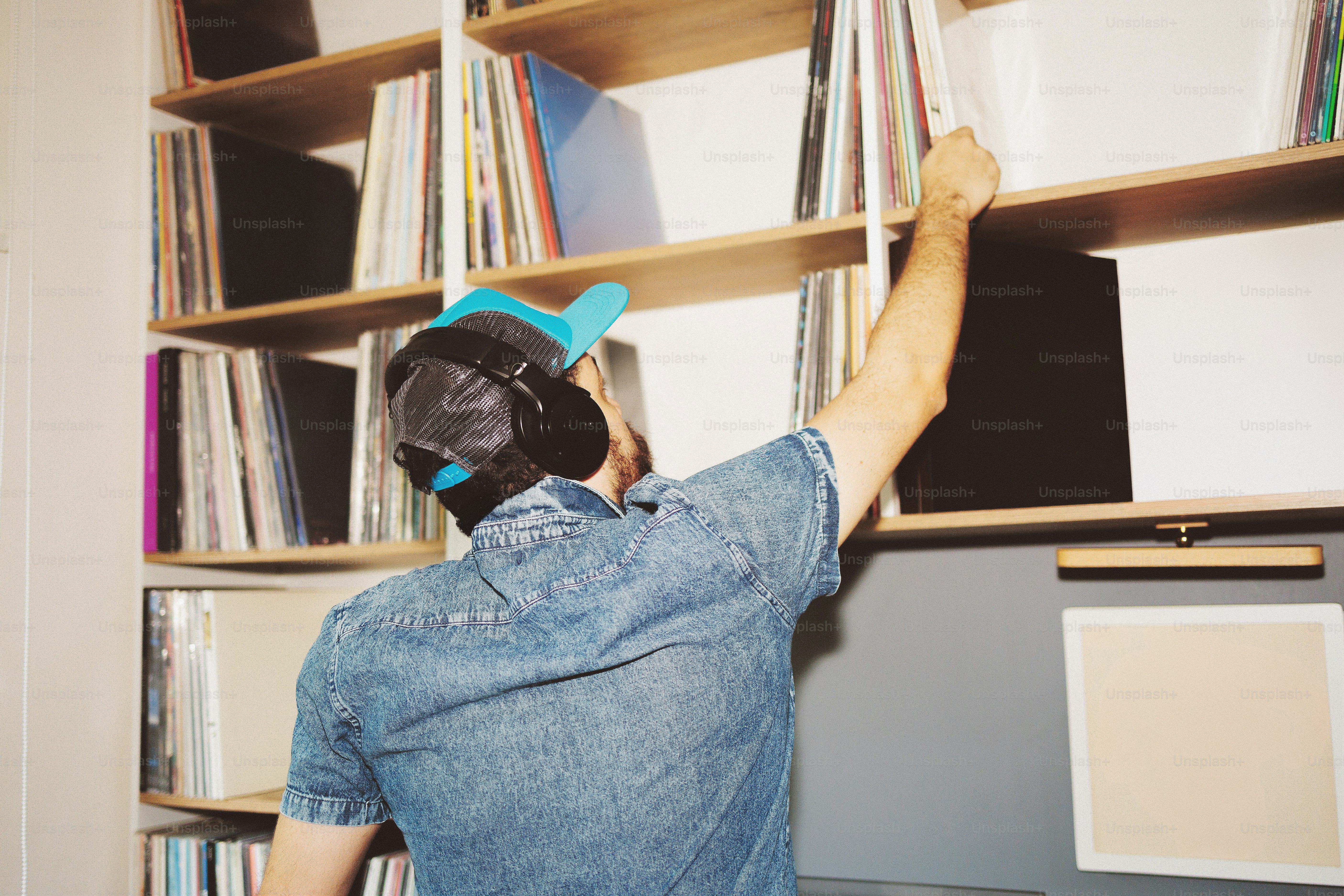 Man reaching for vinyl record on shelf. photo – Home decor Image on ...
