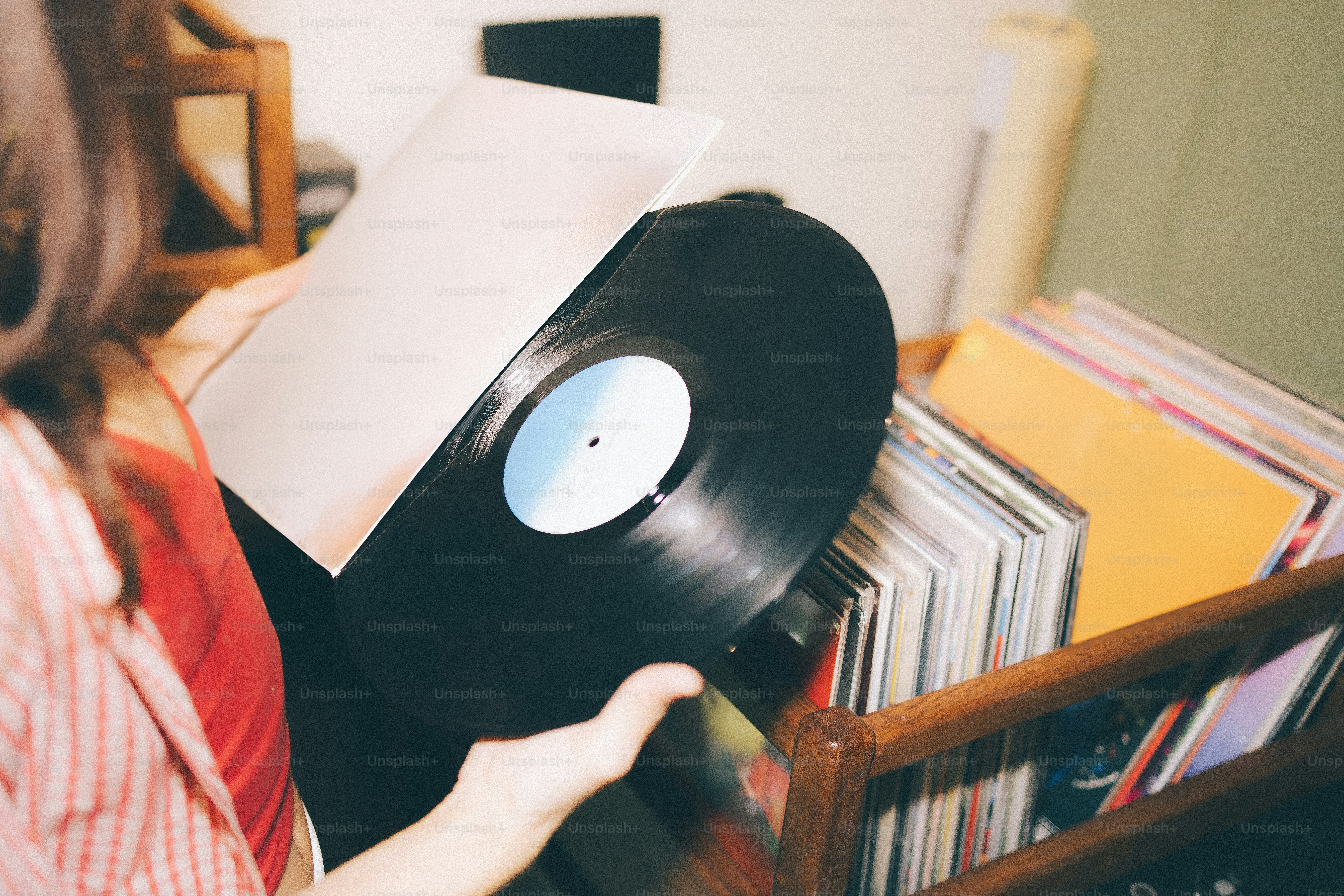 Woman holding a vinyl record from a collection