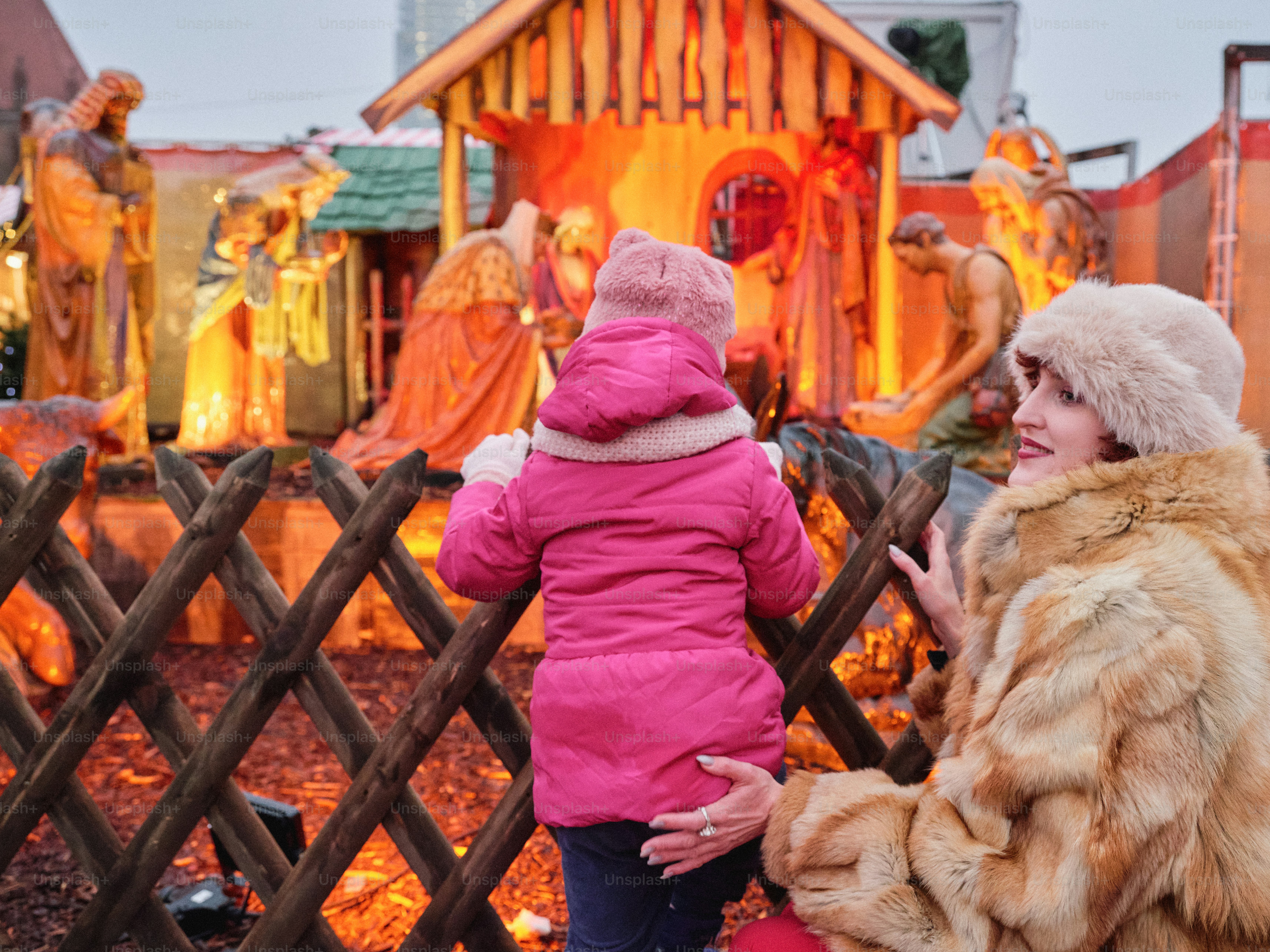 Mother and child view nativity scene at market