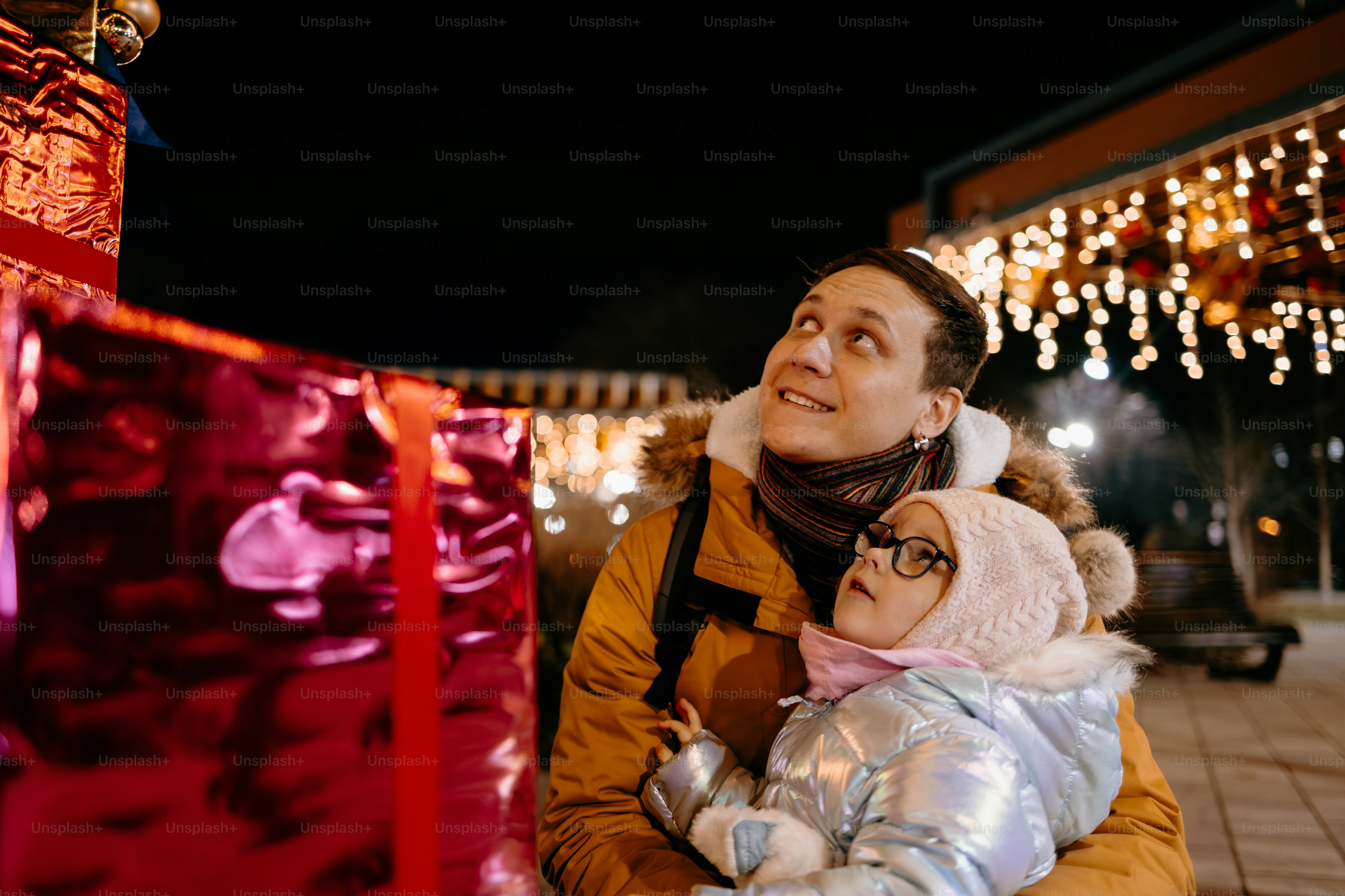Padre e hija mirando las decoraciones navideñas