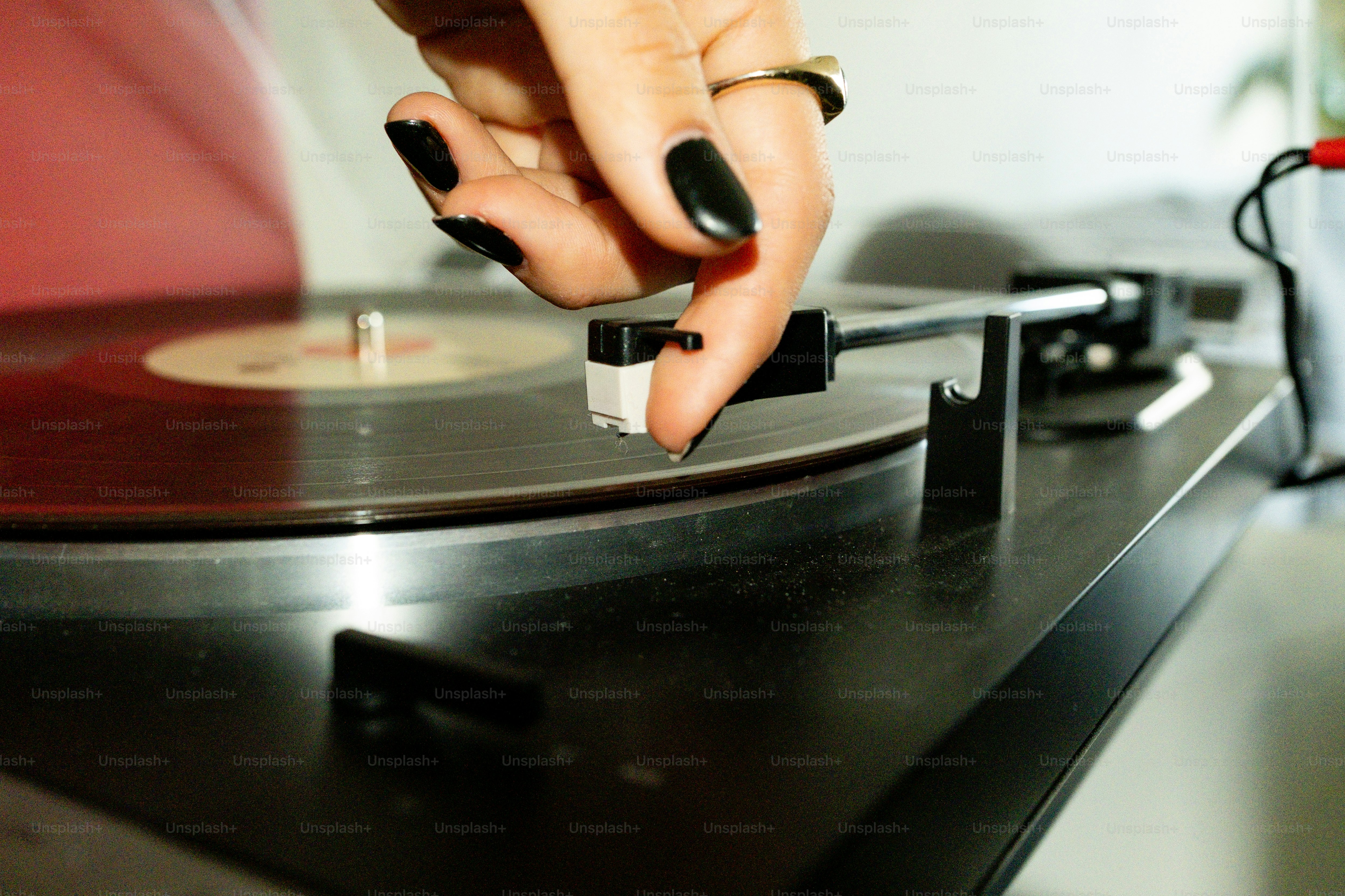 Posare a mano l'ago su un disco in vinile che gira.