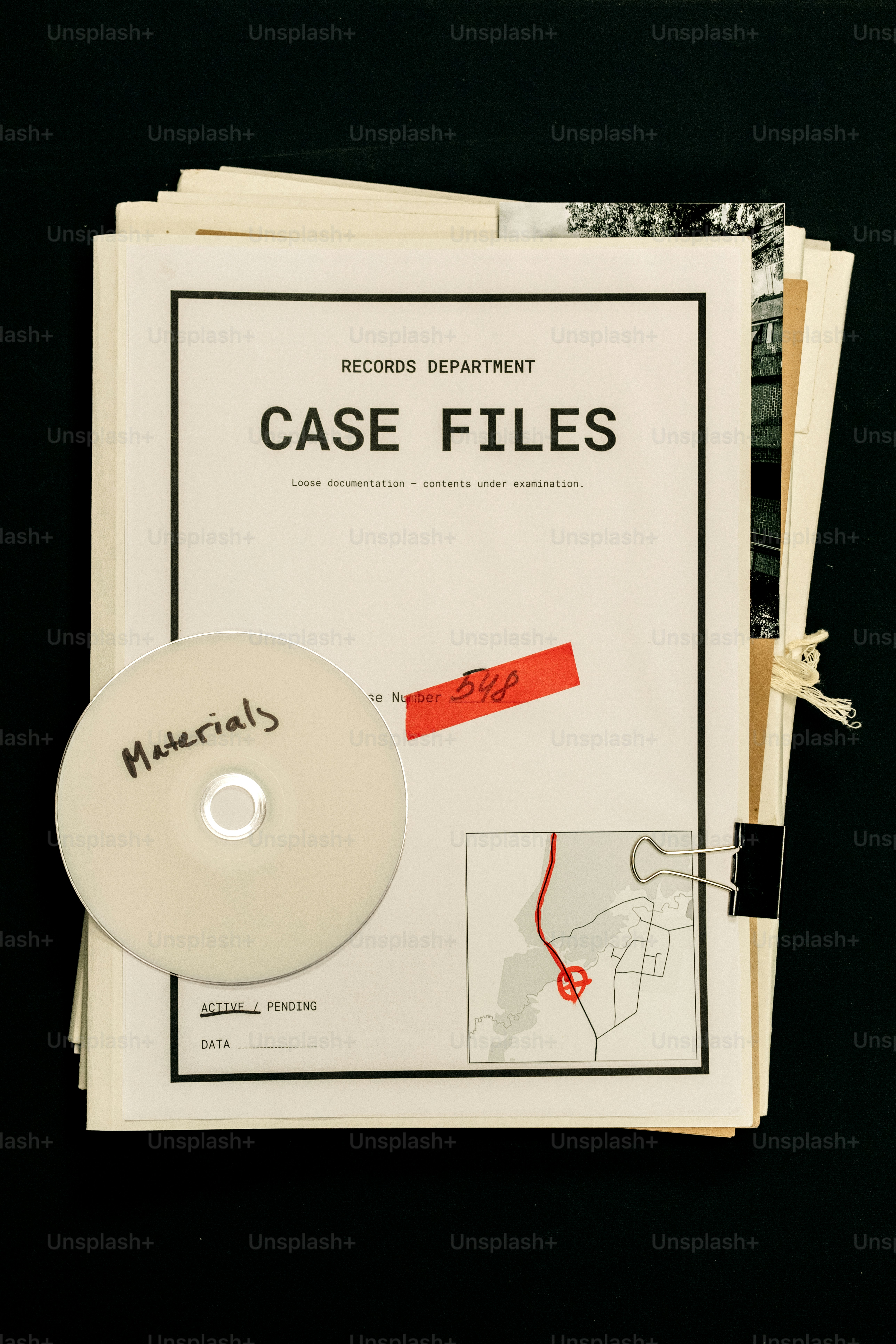 Stack of case files with cd and map