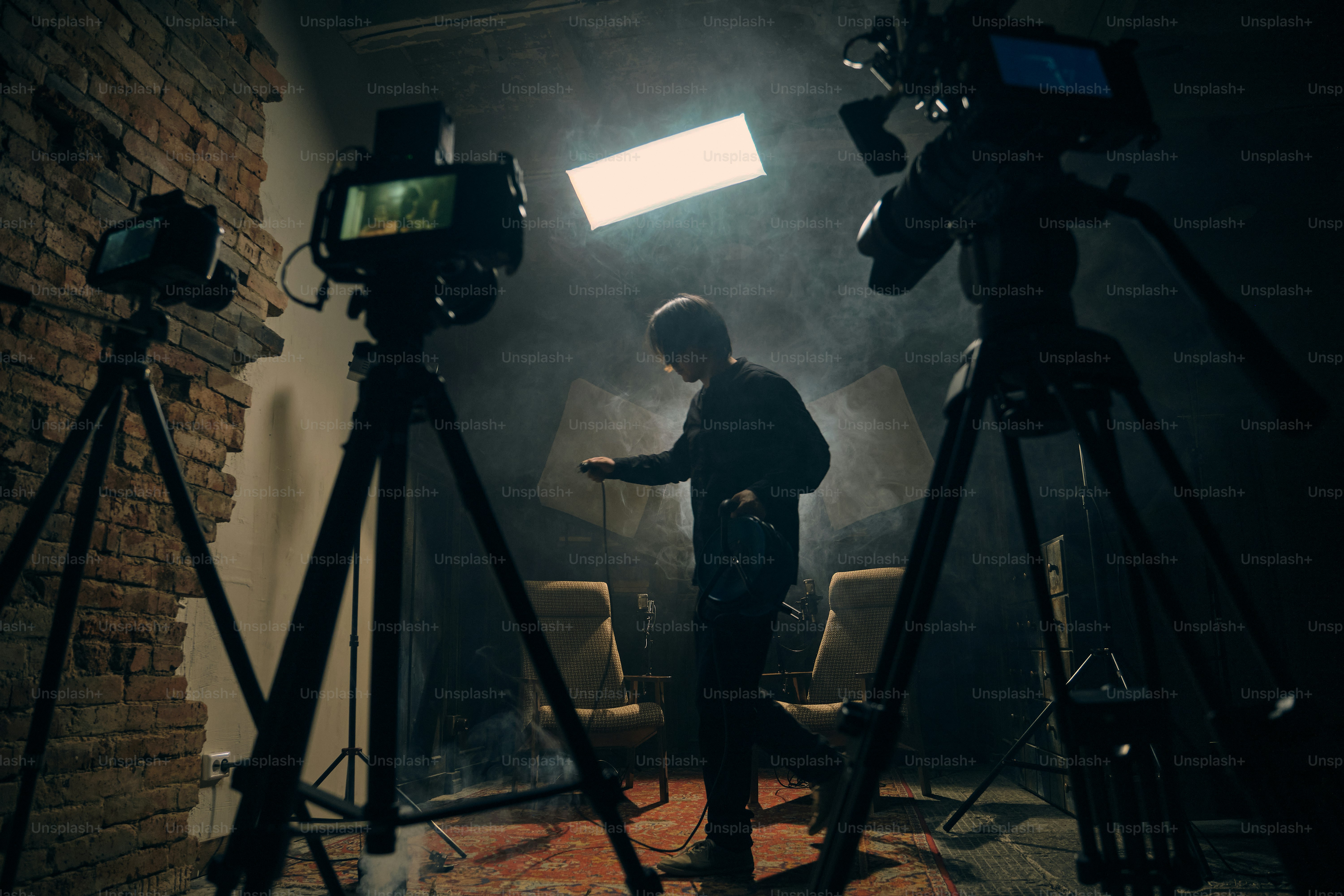 Filmmaker with camera and tripod in studio photo – Advertising Image on ...