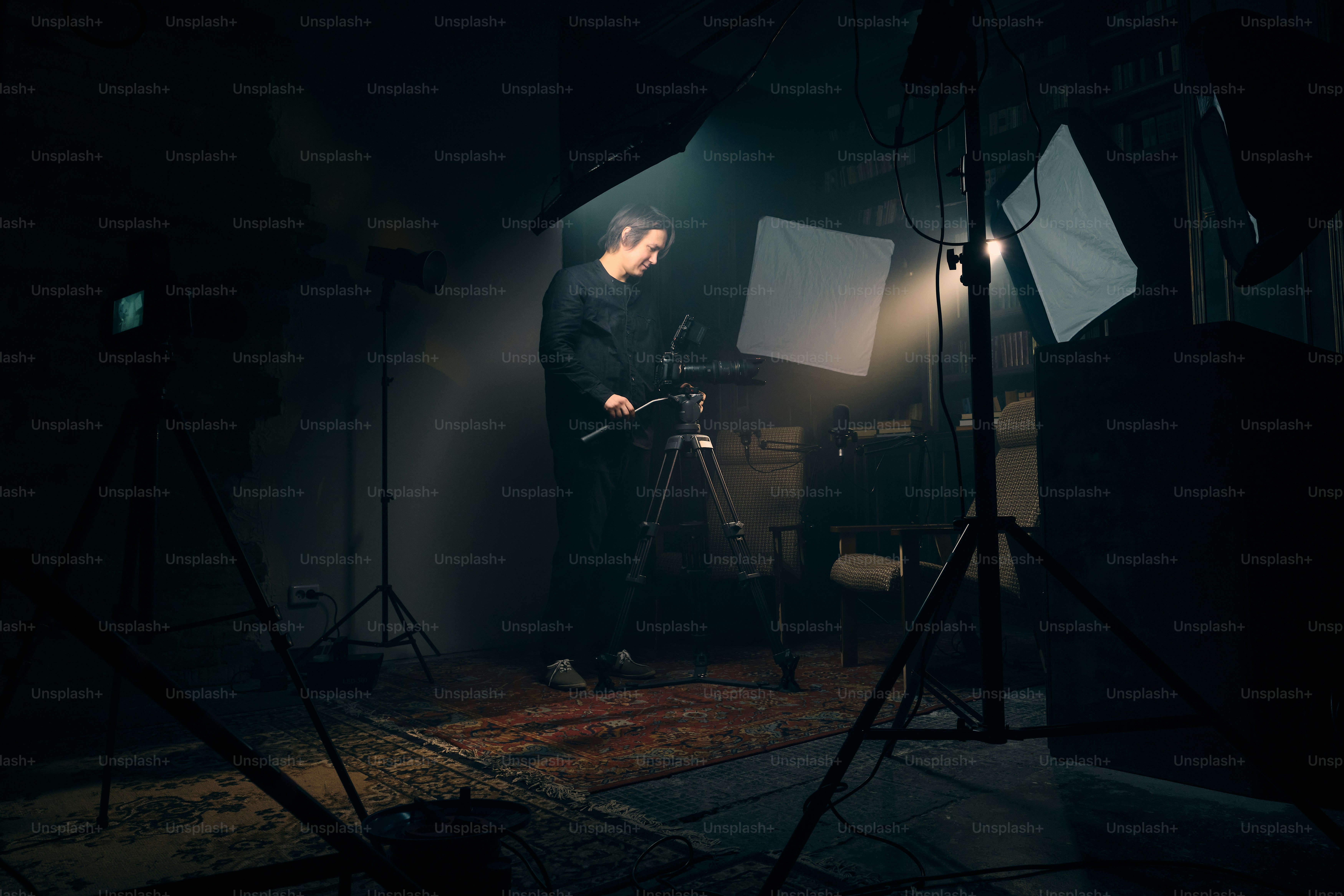 Two cameras filming a person in a dimly lit studio. photo – Camera ...