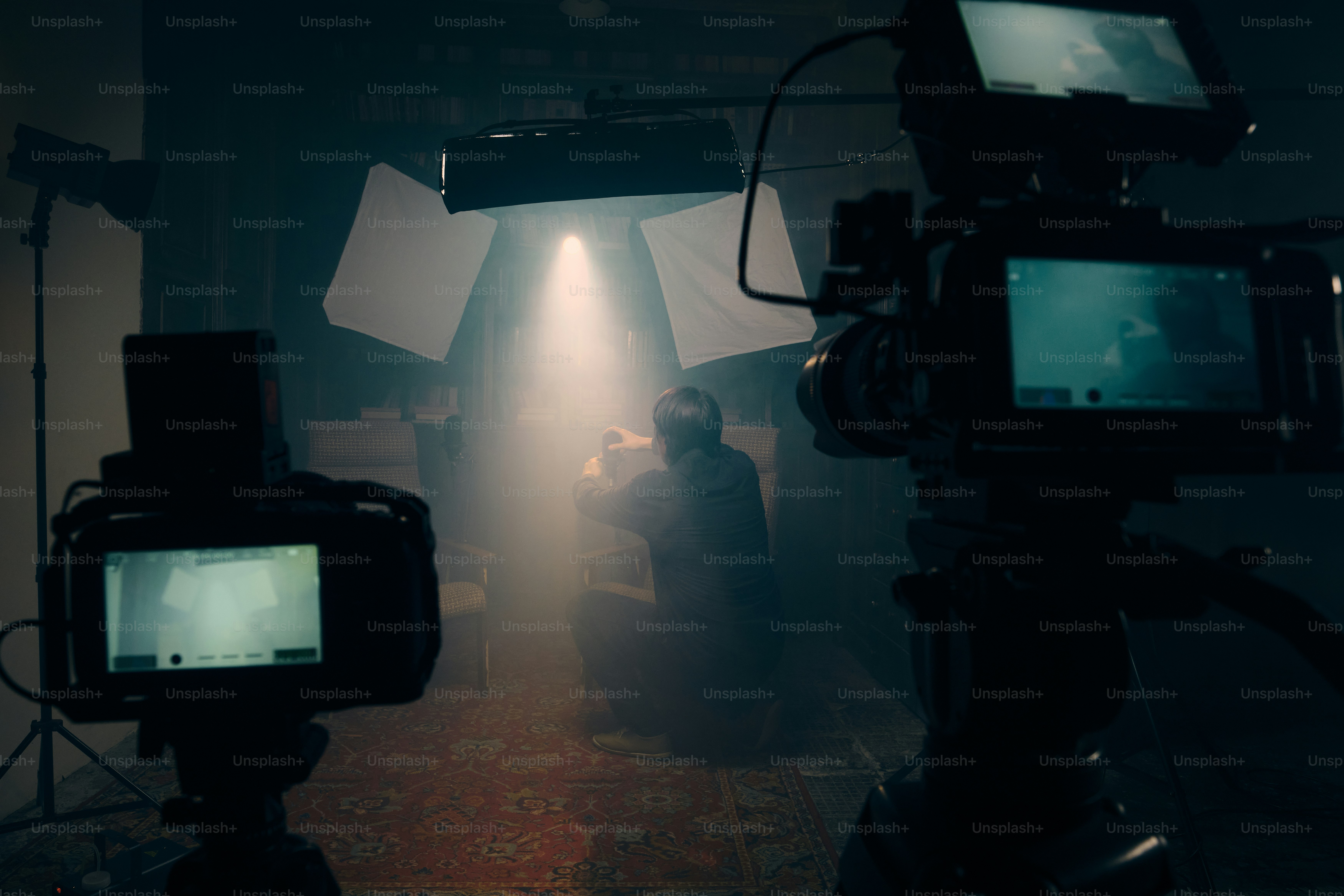 Two cameras filming a person in a dimly lit studio. photo – Camera ...
