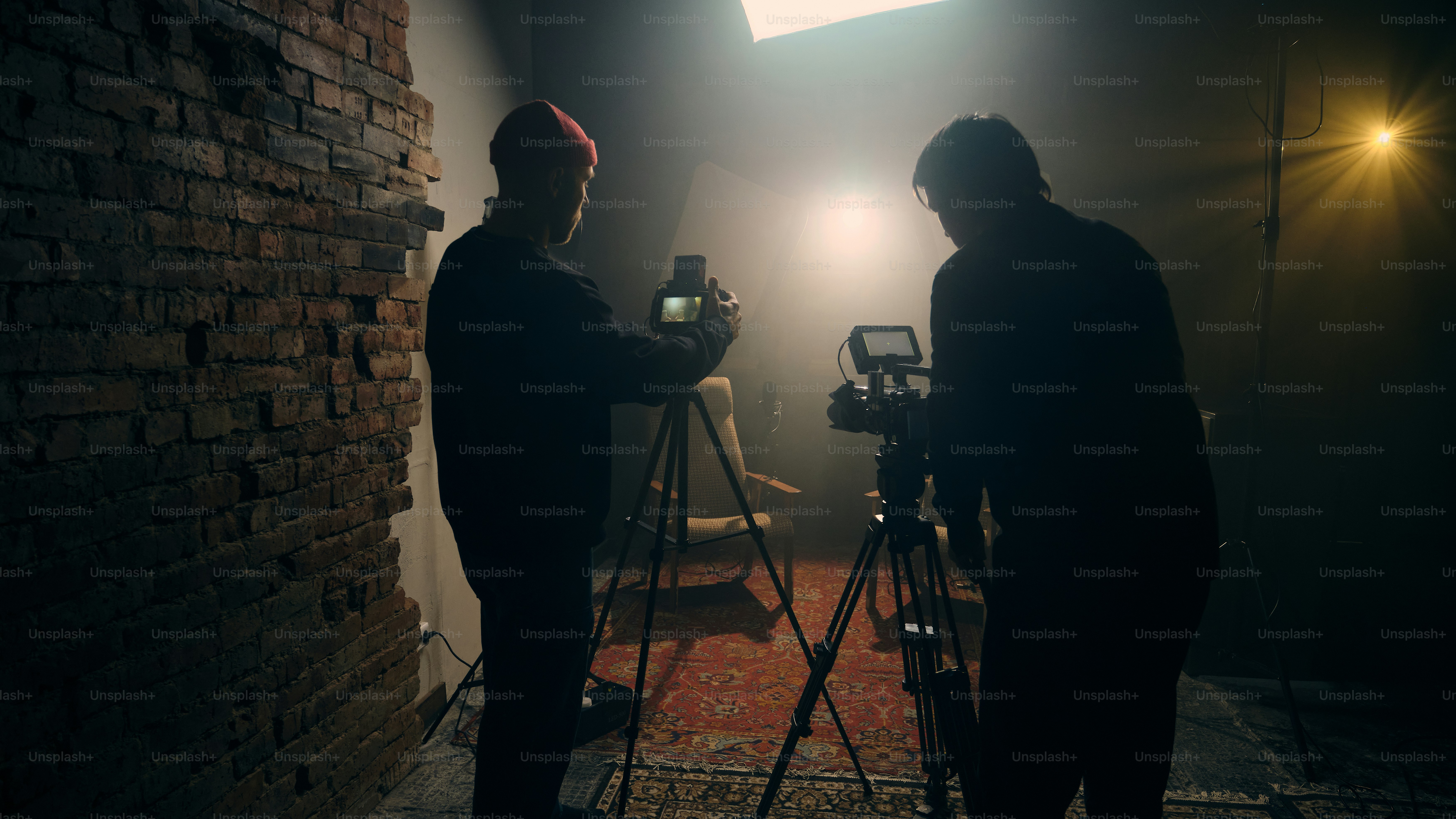 Two cameras filming a person in a dimly lit studio. photo – Camera ...