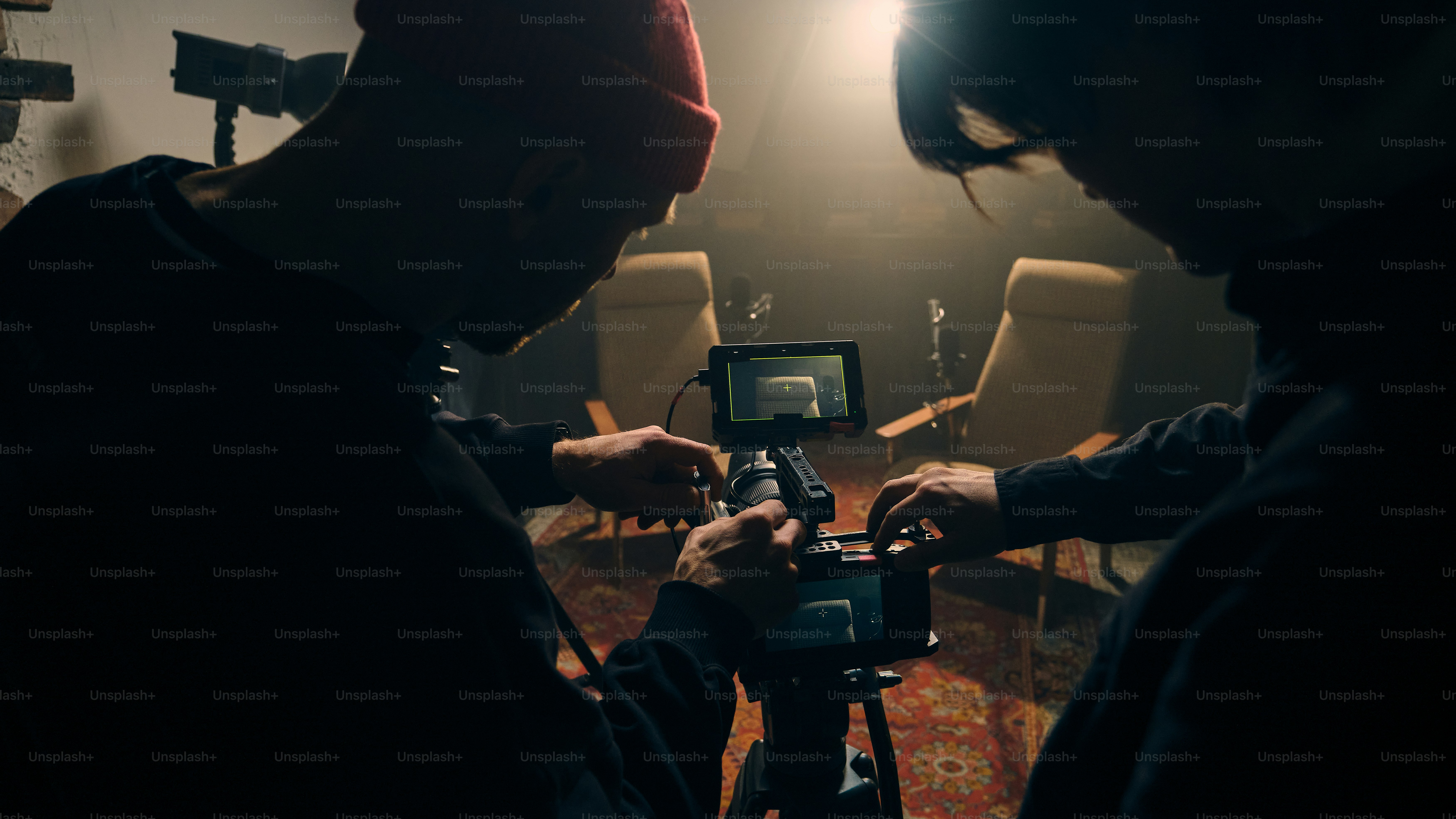 Filmmakers setting up camera equipment in studio.