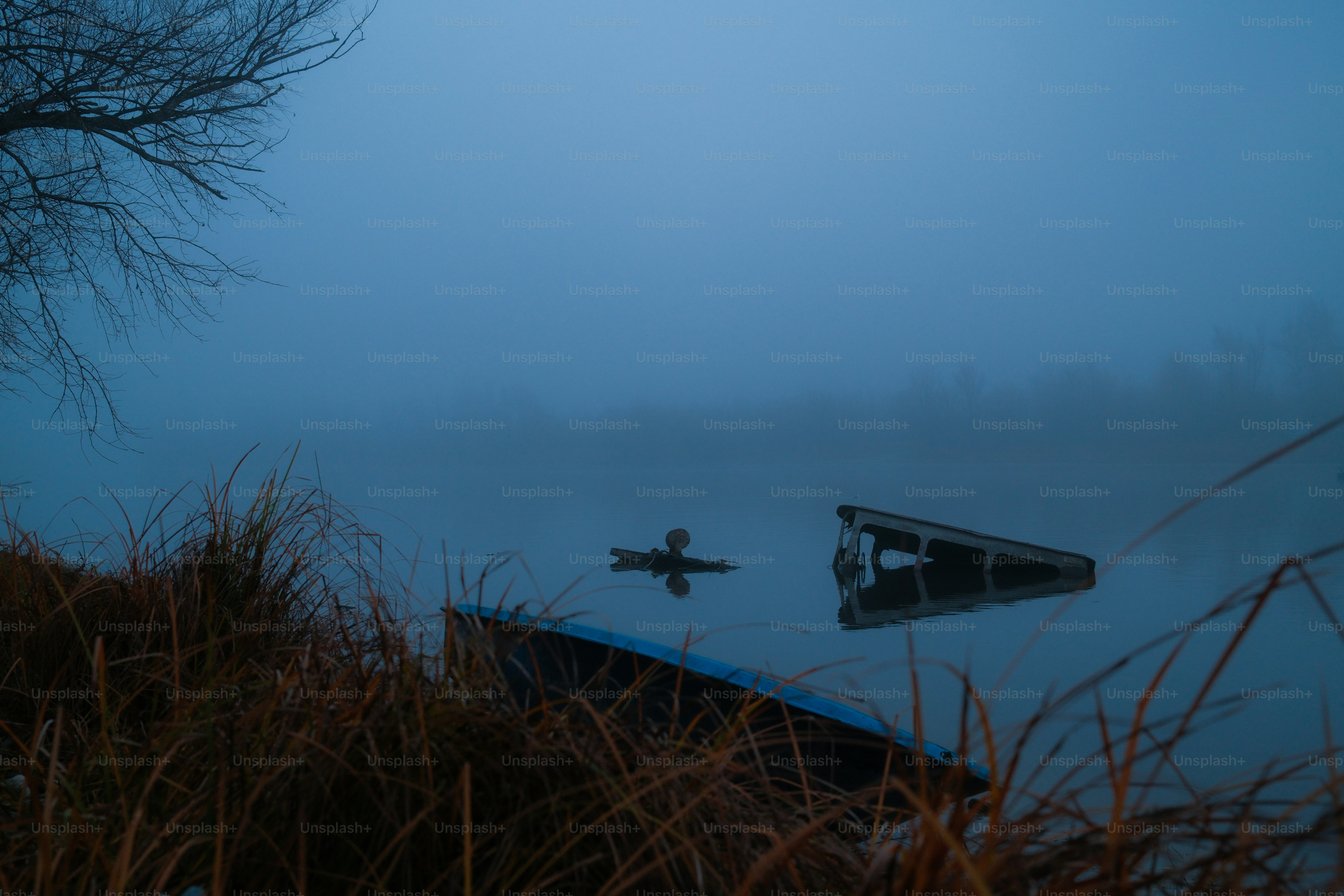 Two boats partially submerged in foggy water
