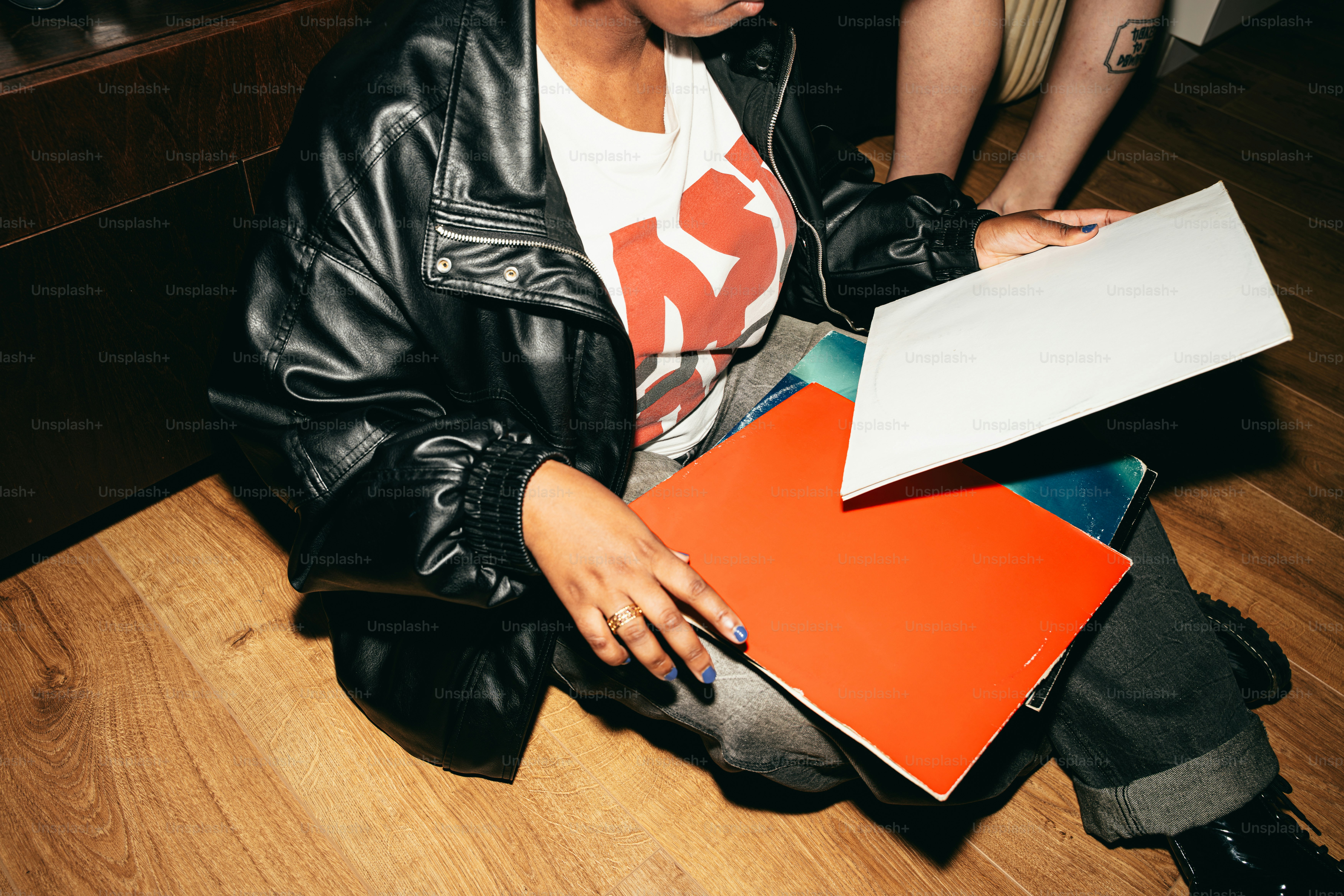 Person in leather jacket holding records