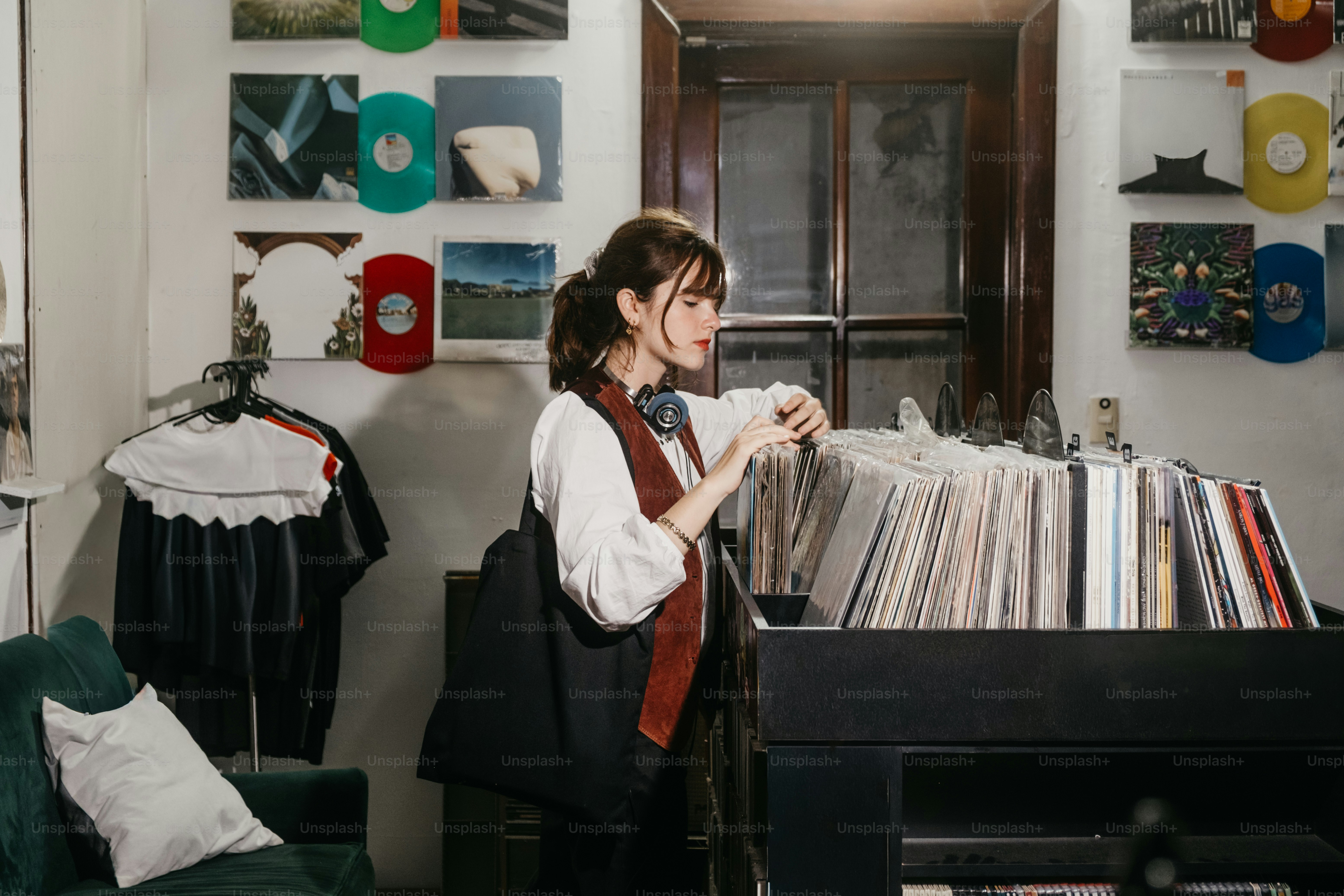 Mujer hojeando discos en una habitación con colección de vinilos
