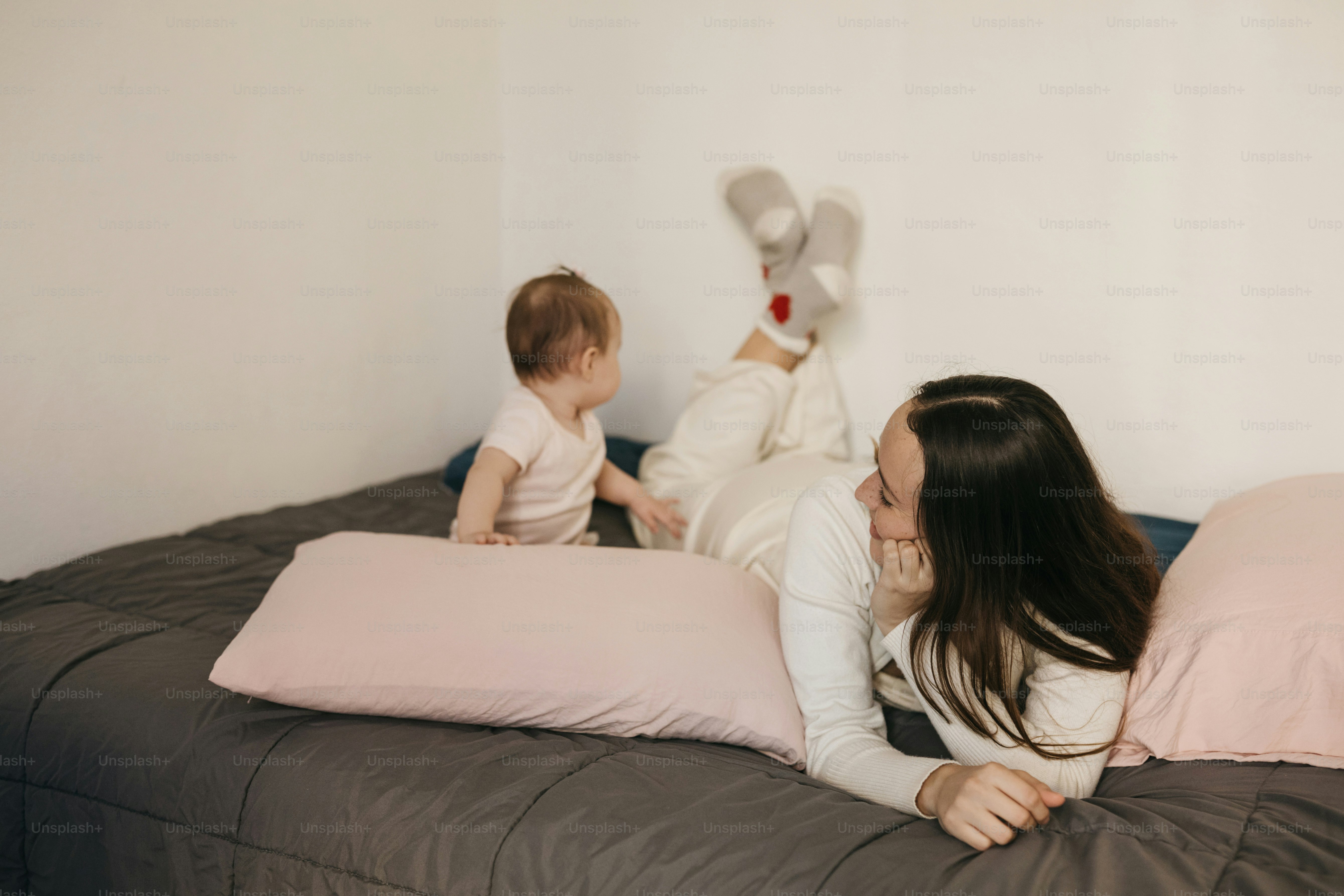 Mutter und Baby spielen auf einem Bett