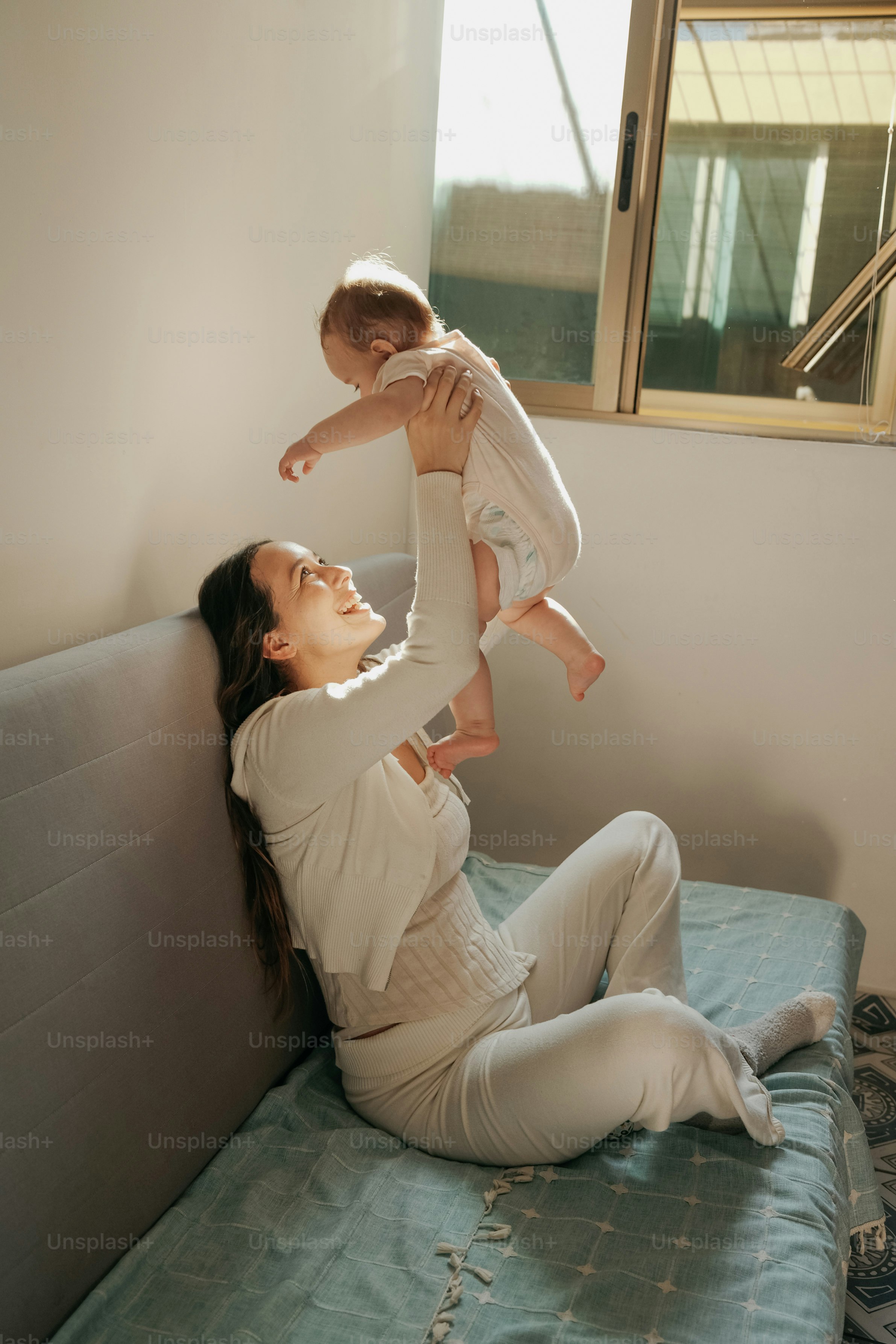 Mutter, die ihr Baby in die Luft hält.