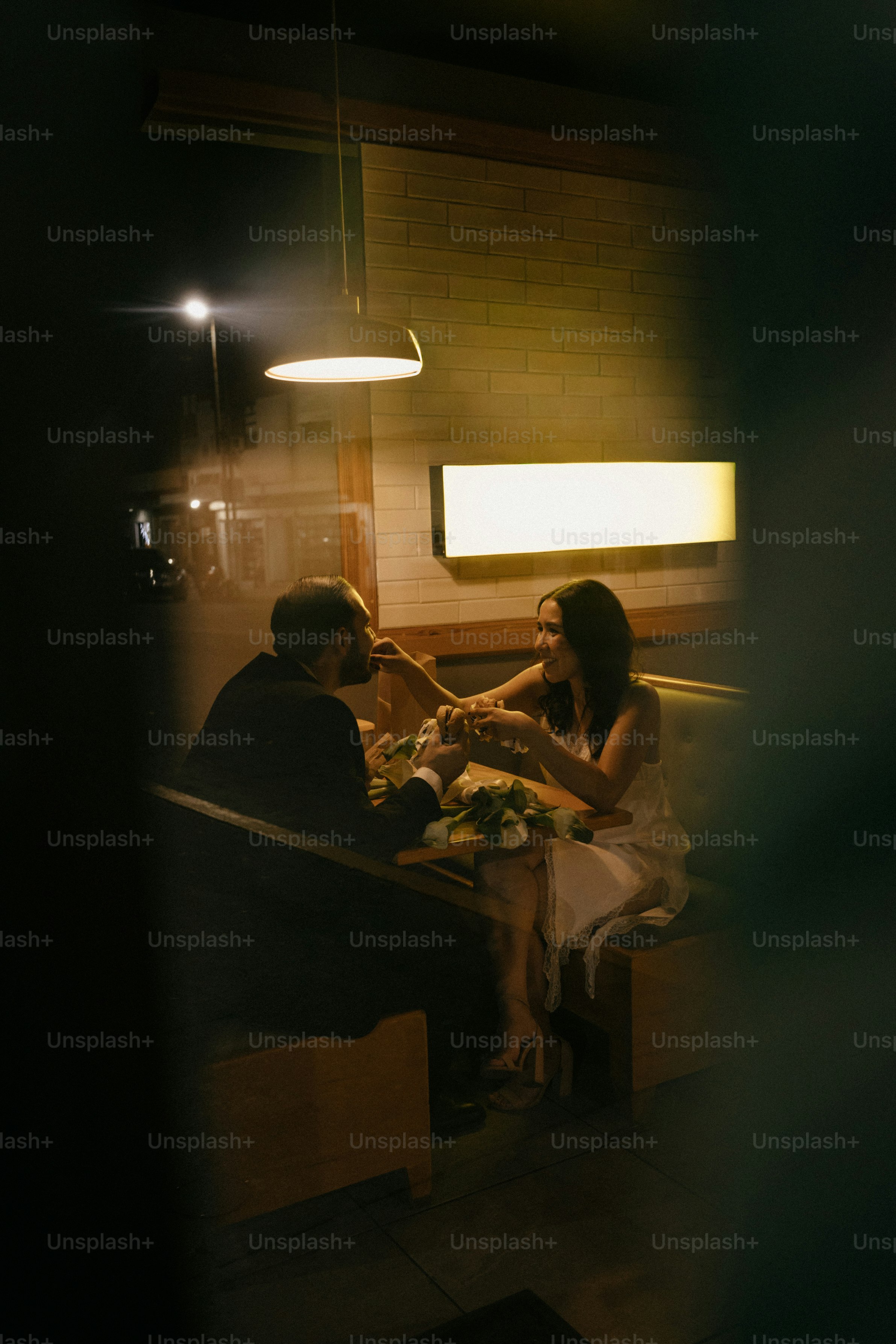 Paar isst an einem Stand in einem schwach beleuchteten Restaurant