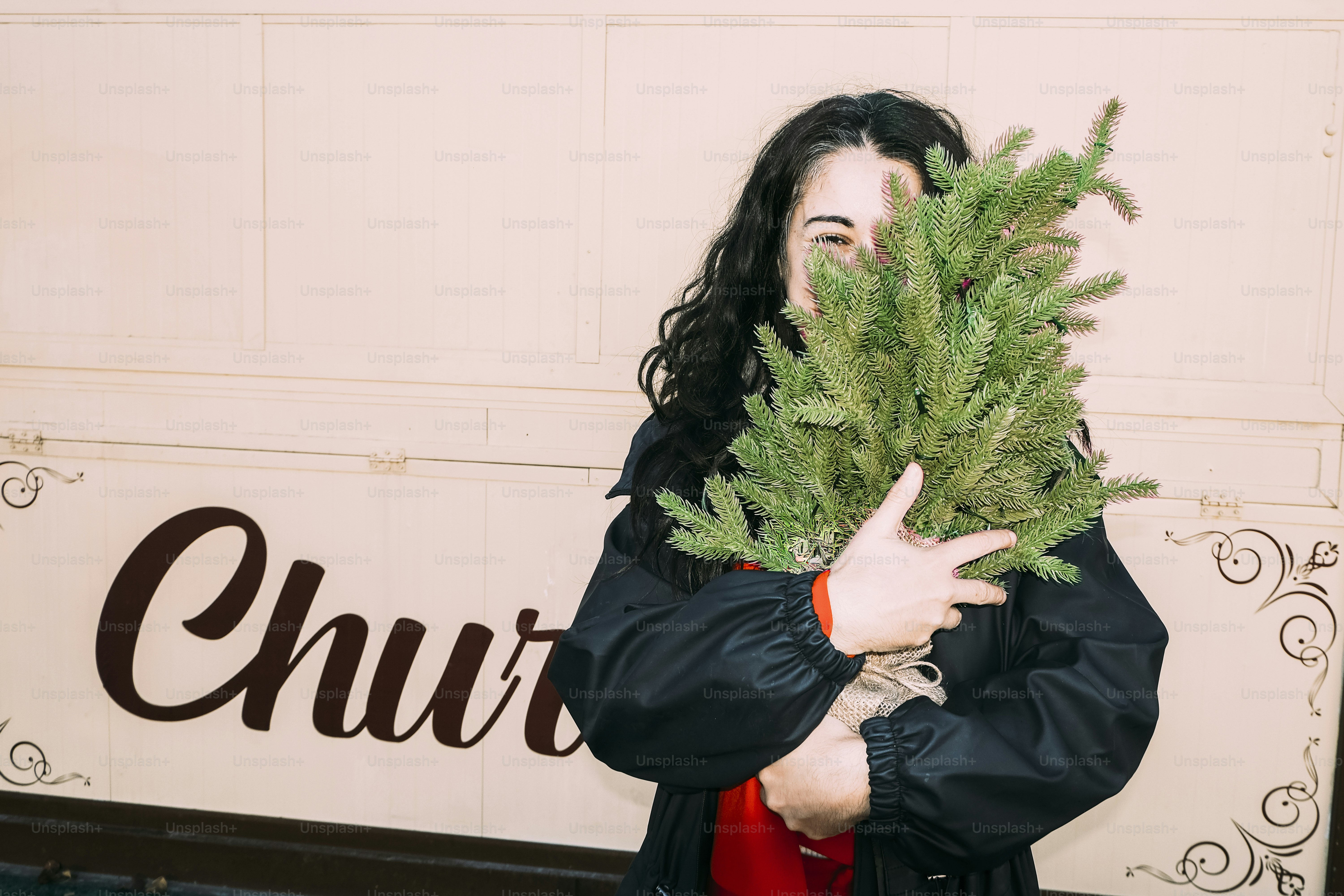 Woman holding a small evergreen tree