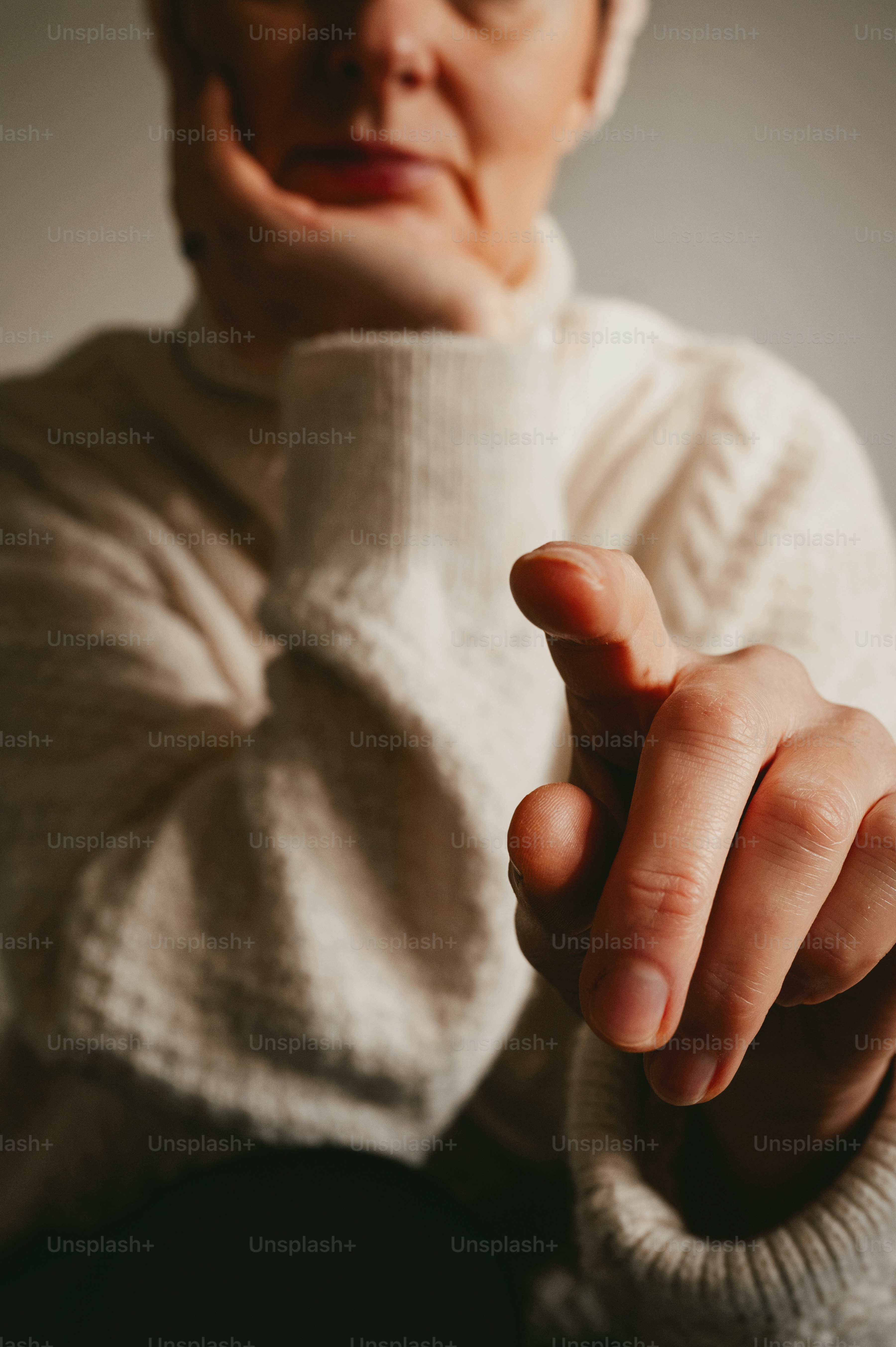 A person's hand pointing forward, face blurred