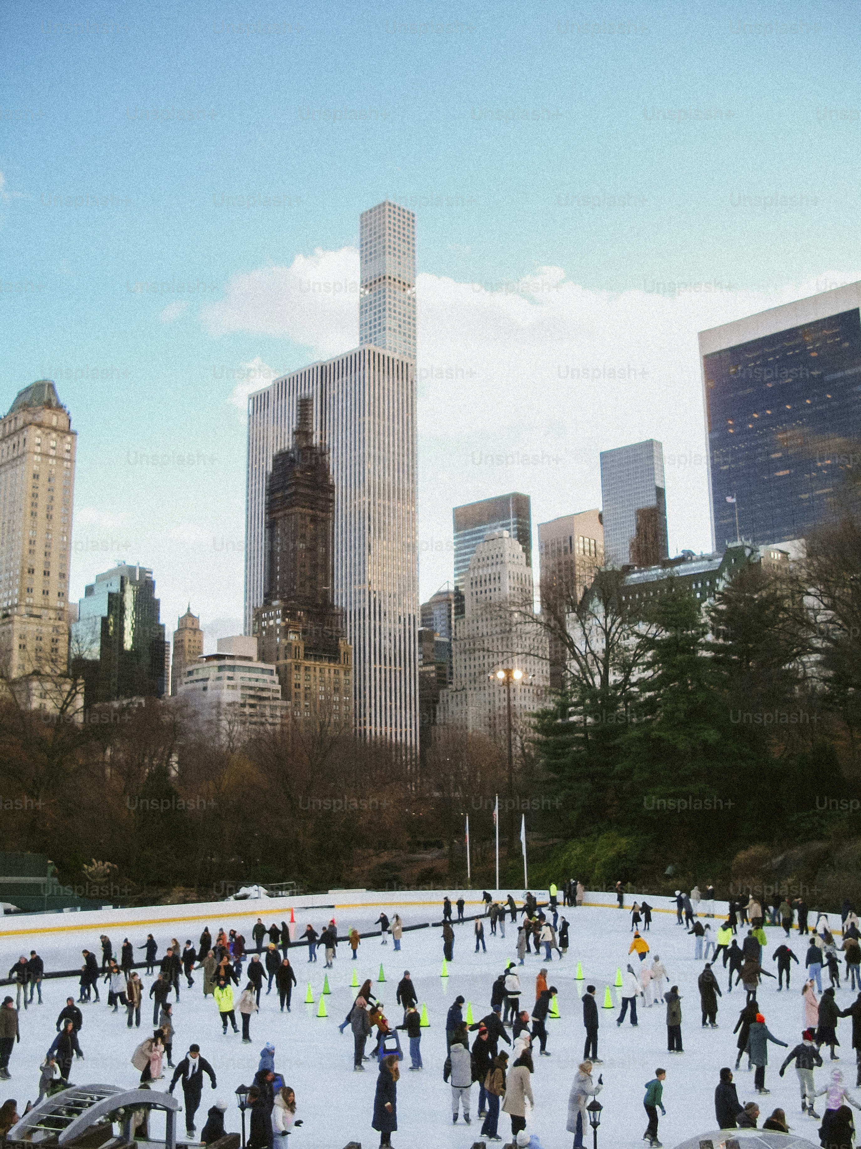 Des gens patinant sur glace avec la silhouette de la ville en arrière-plan