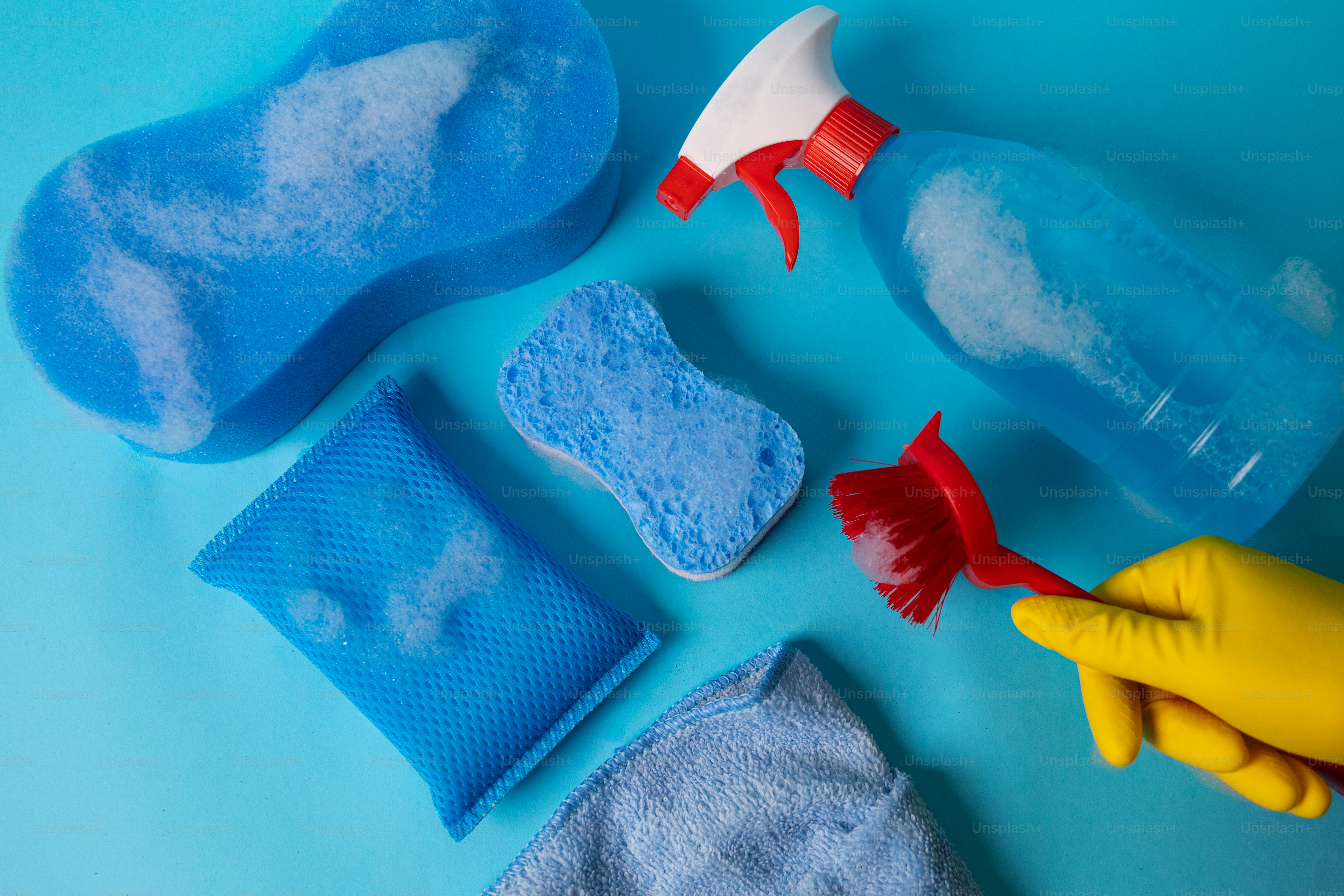 Produits de nettoyage incluant éponges, vaporisateur et brosse