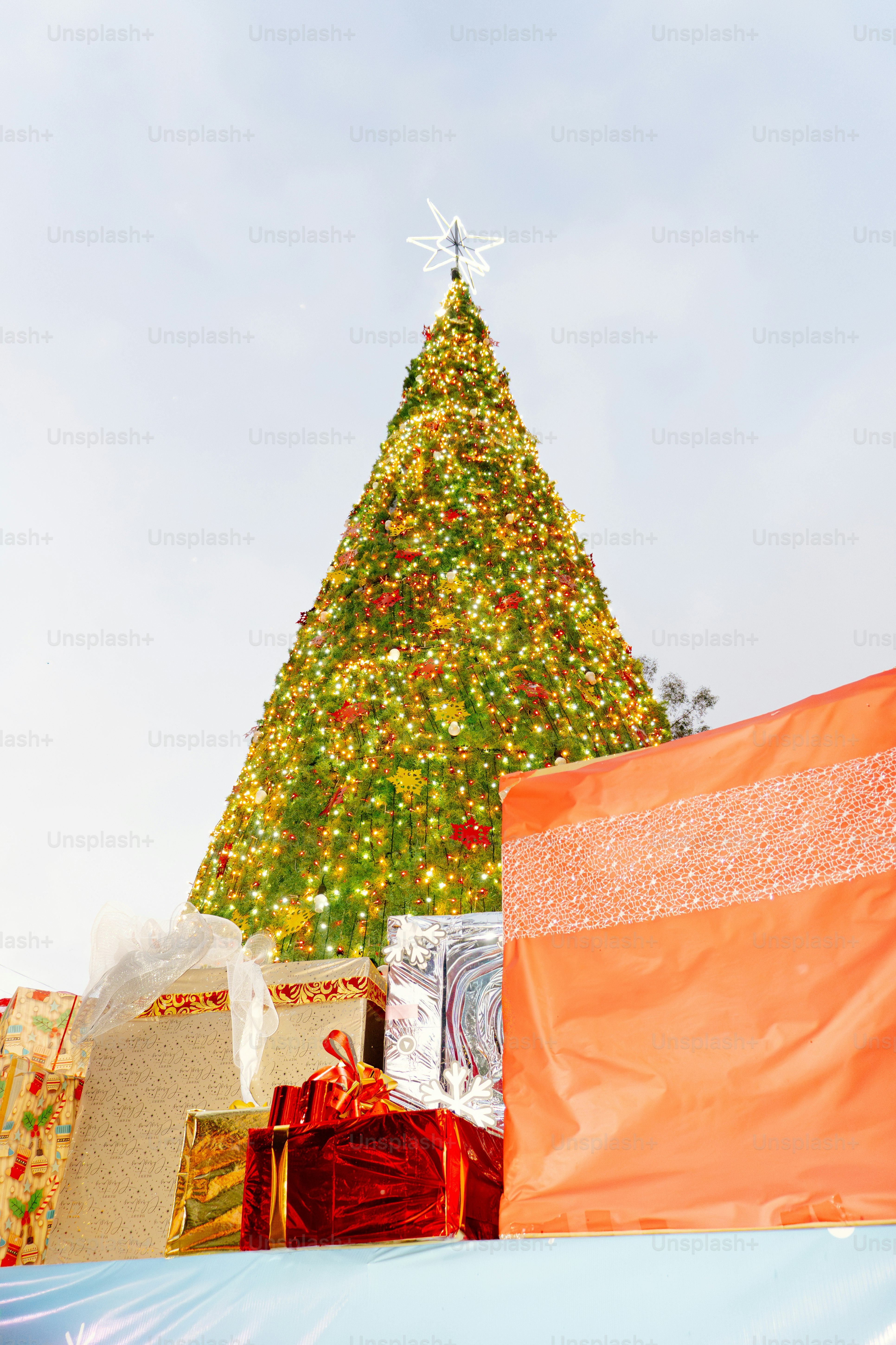 Decorated christmas tree with gifts in-focus wrapped gifts.