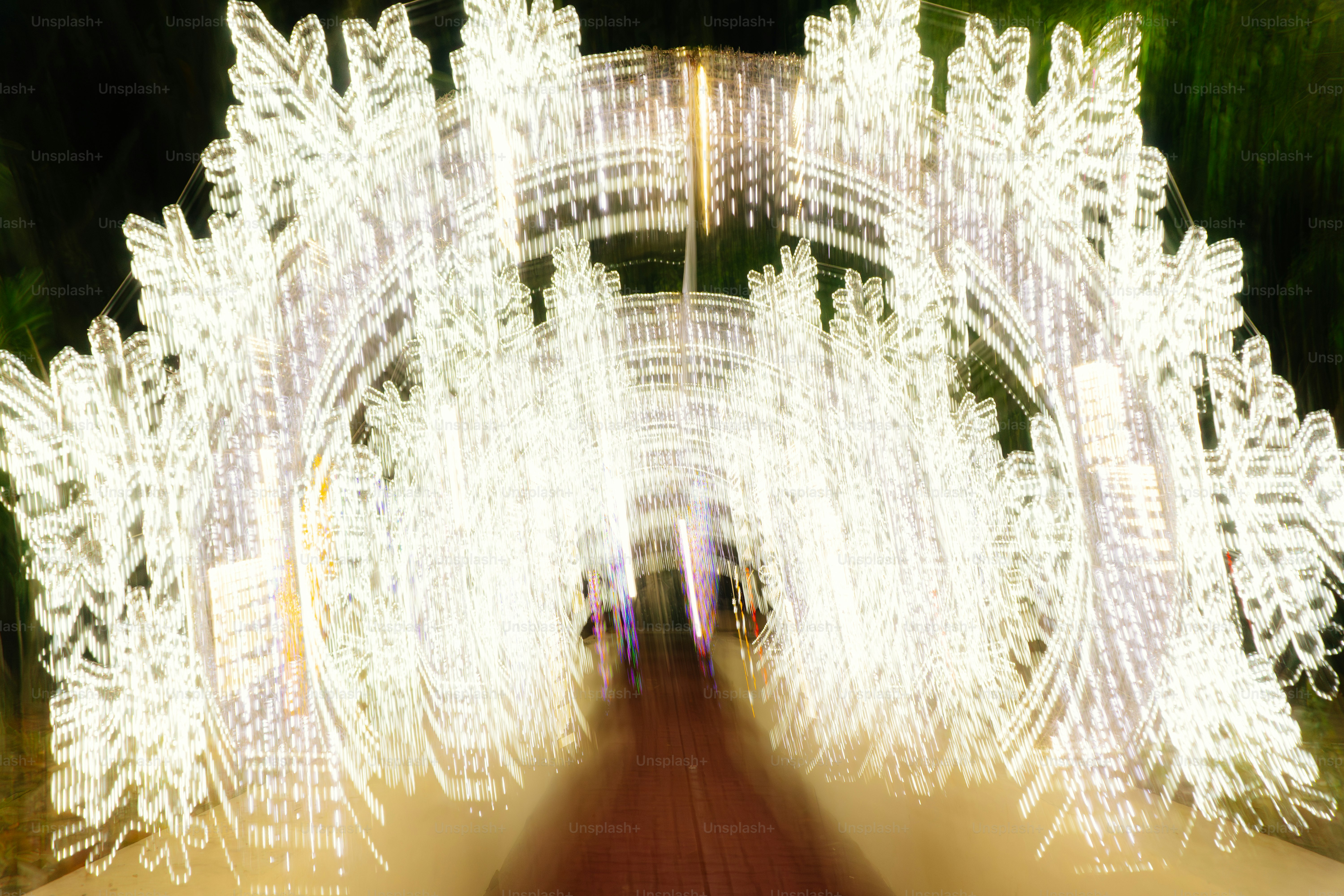 Tunnel of bright white snowflake lights at night