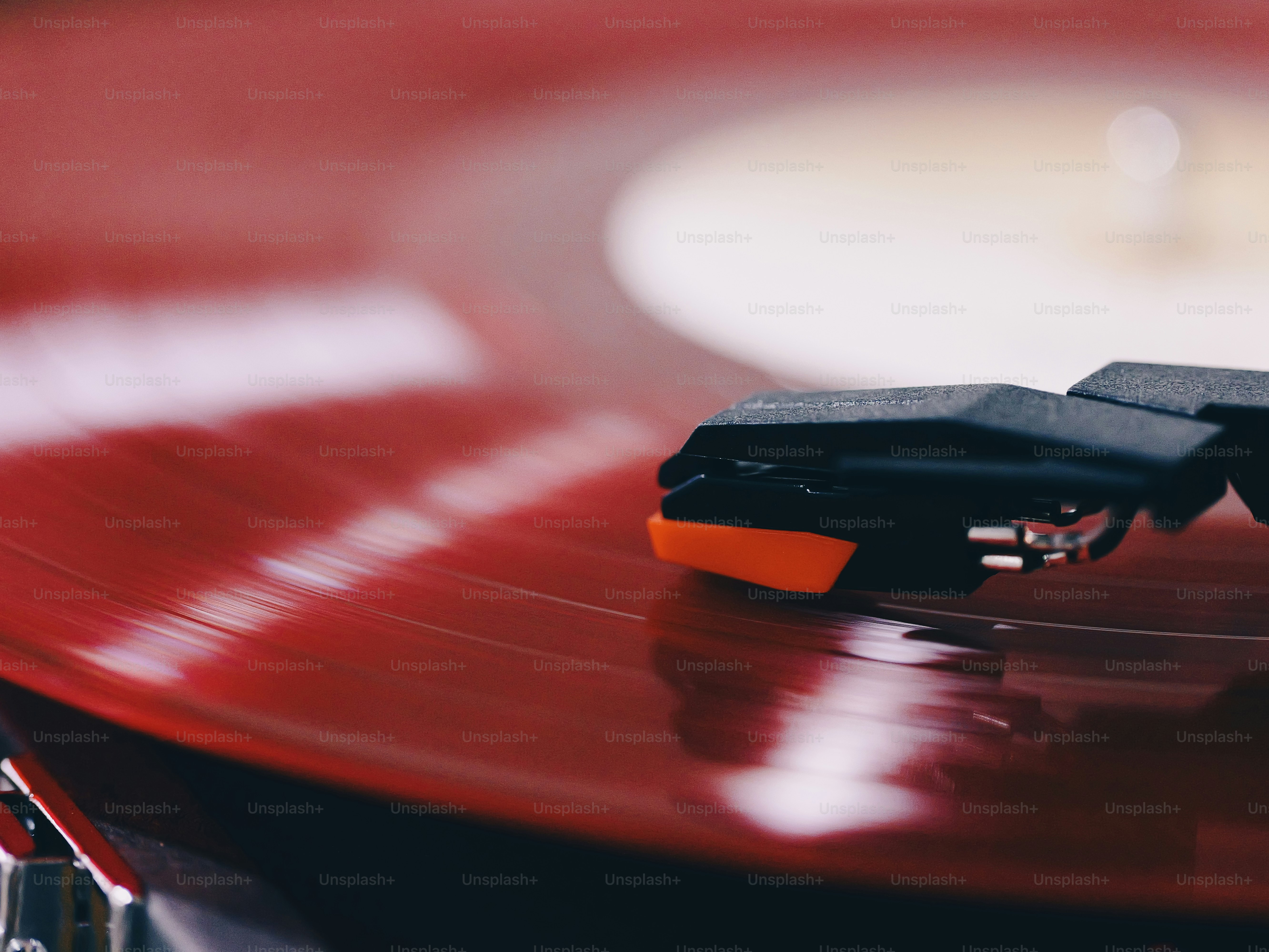 Red vinyl record playing on turntable