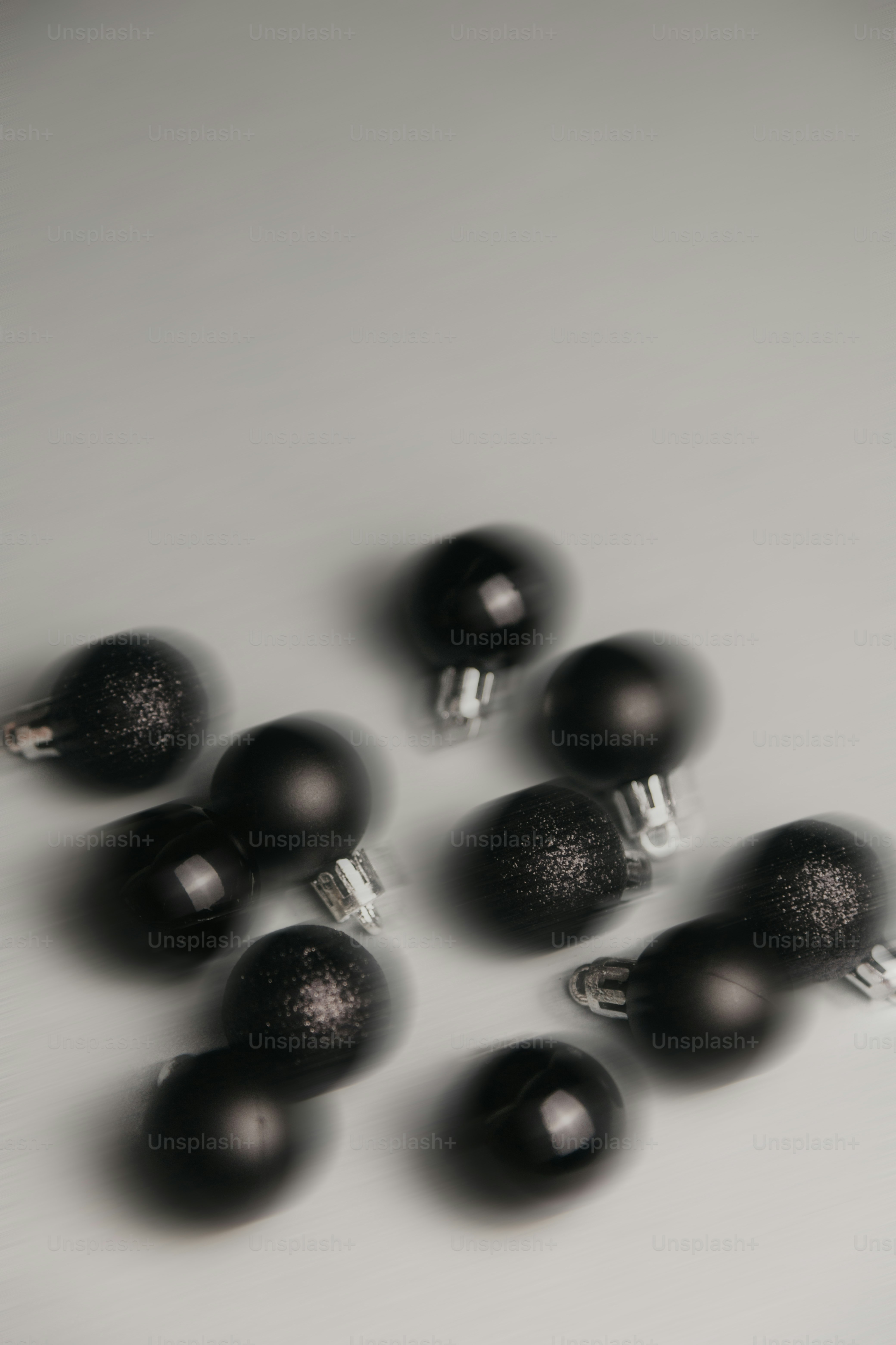 Verstreute schwarze Weihnachtsdekorationen auf einer grauen Oberfläche