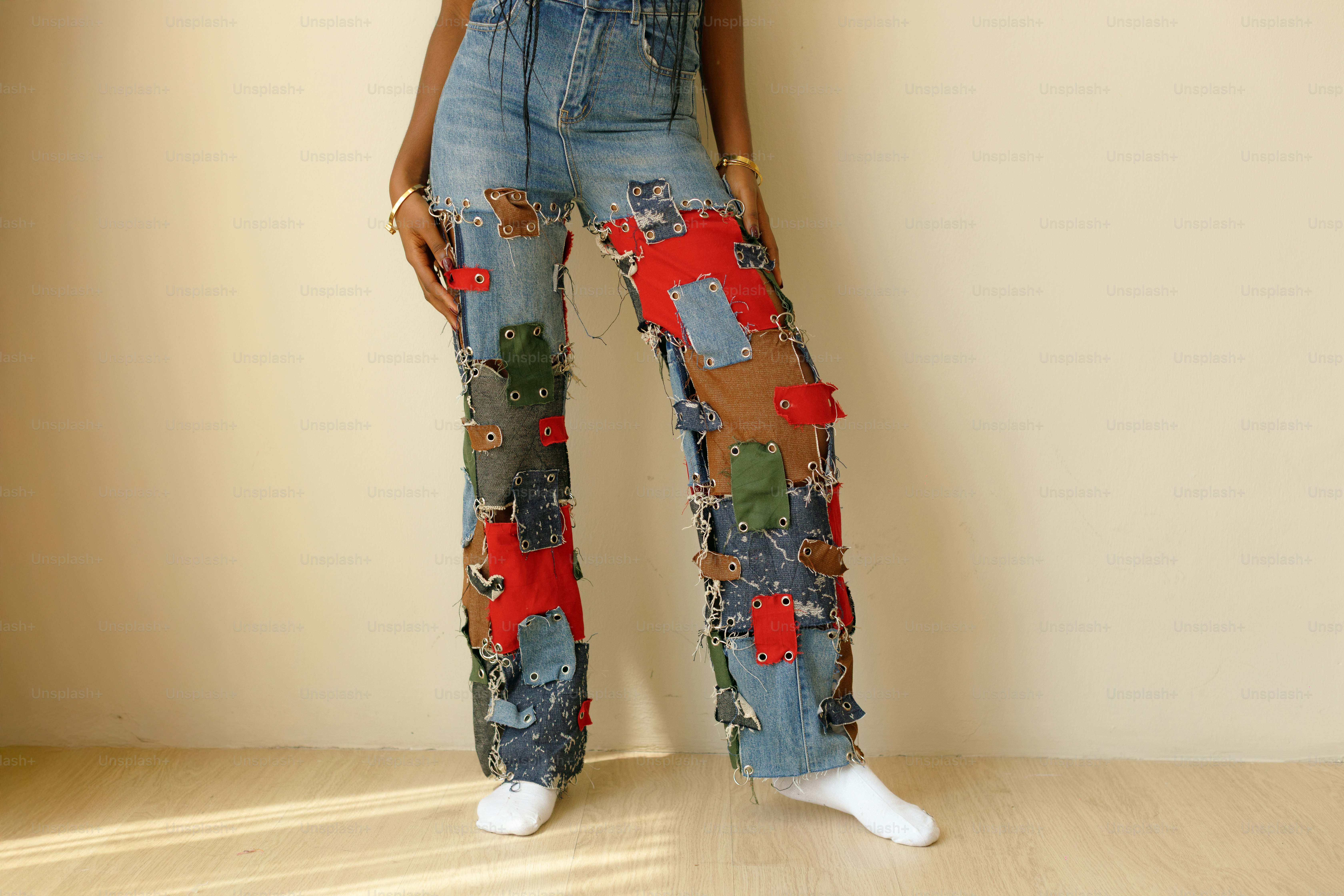 Person wearing patched and ripped denim jeans